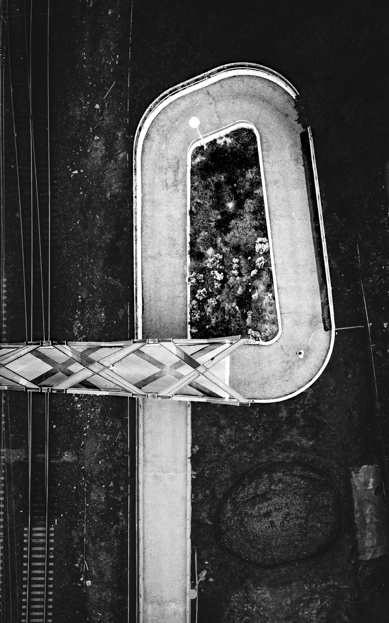 A black and white image of a curved staircase with a railing, viewed from above.