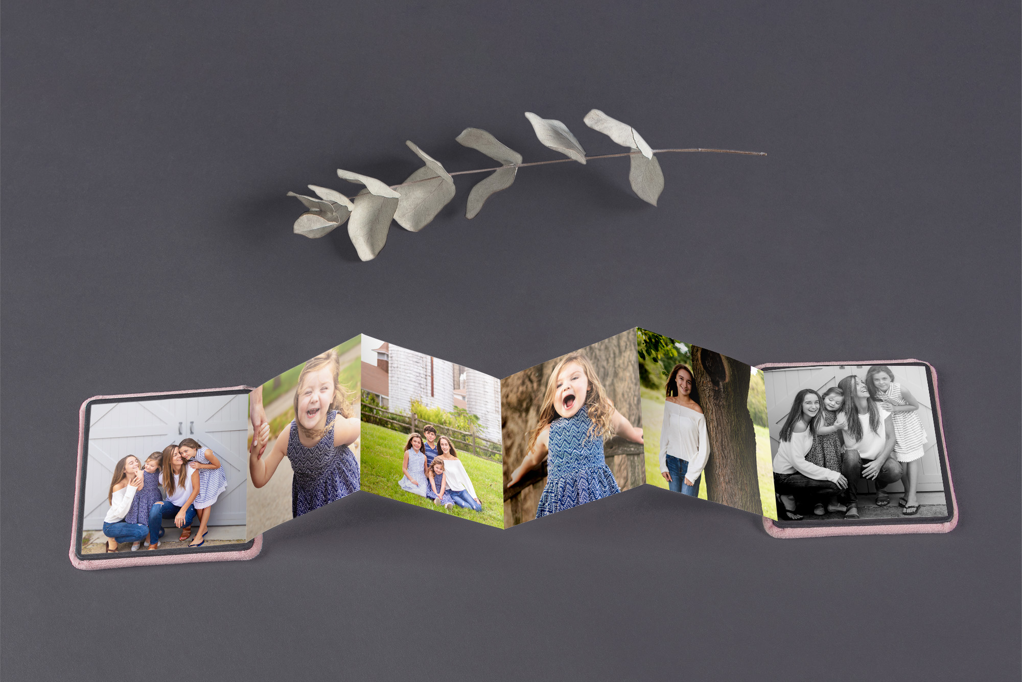 Open photo album with multiple pictures of children and family moments, on a dark surface.