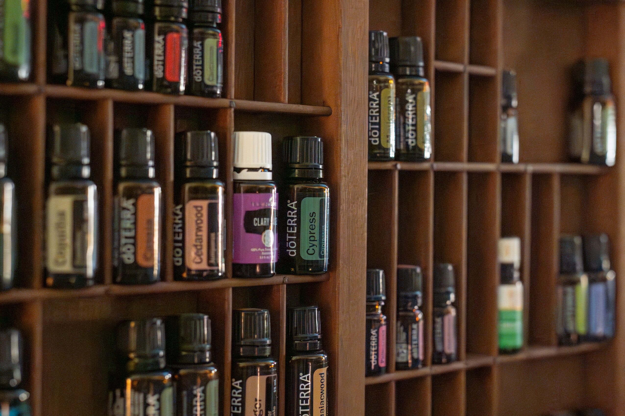 Shelves filled with small bottles of essential oils or similar products, organized in a grid pattern.