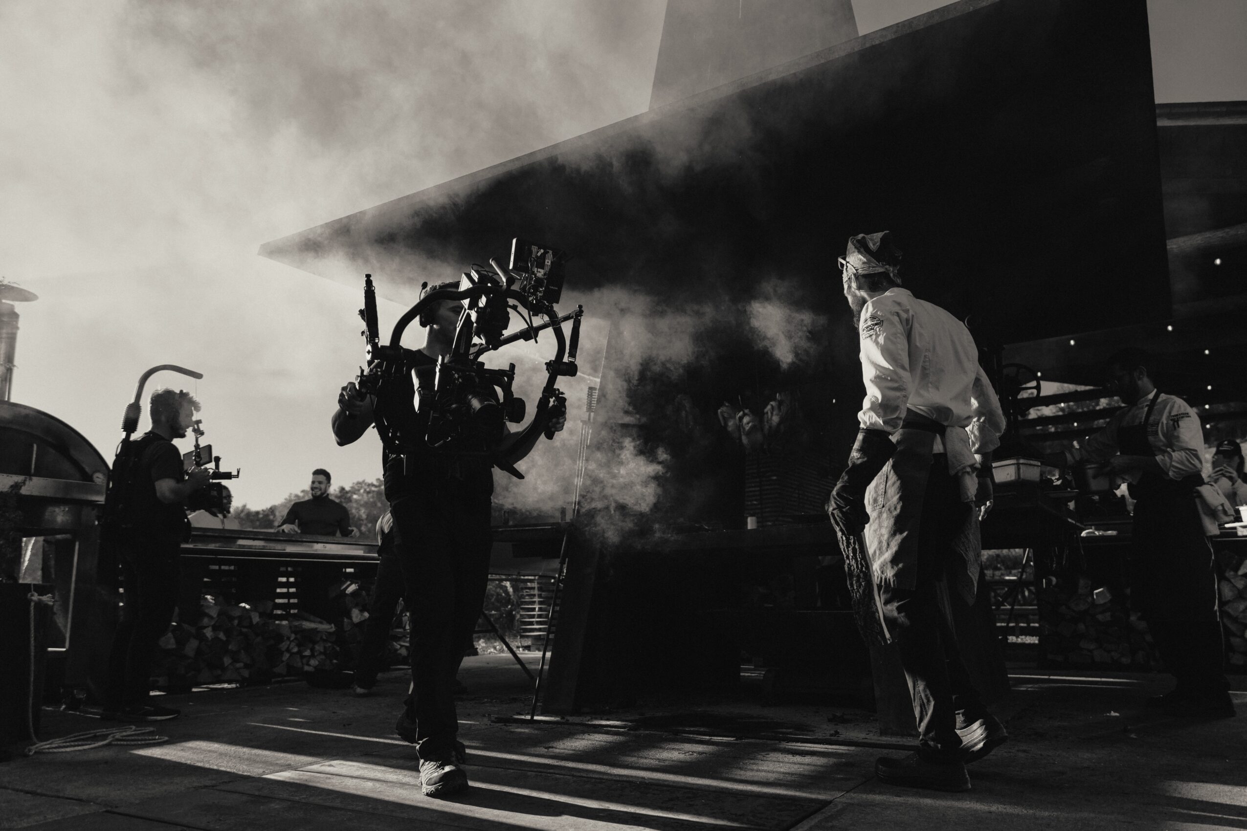 People working on an aircraft with smoke and equipment, in a hangar or workshop setting.