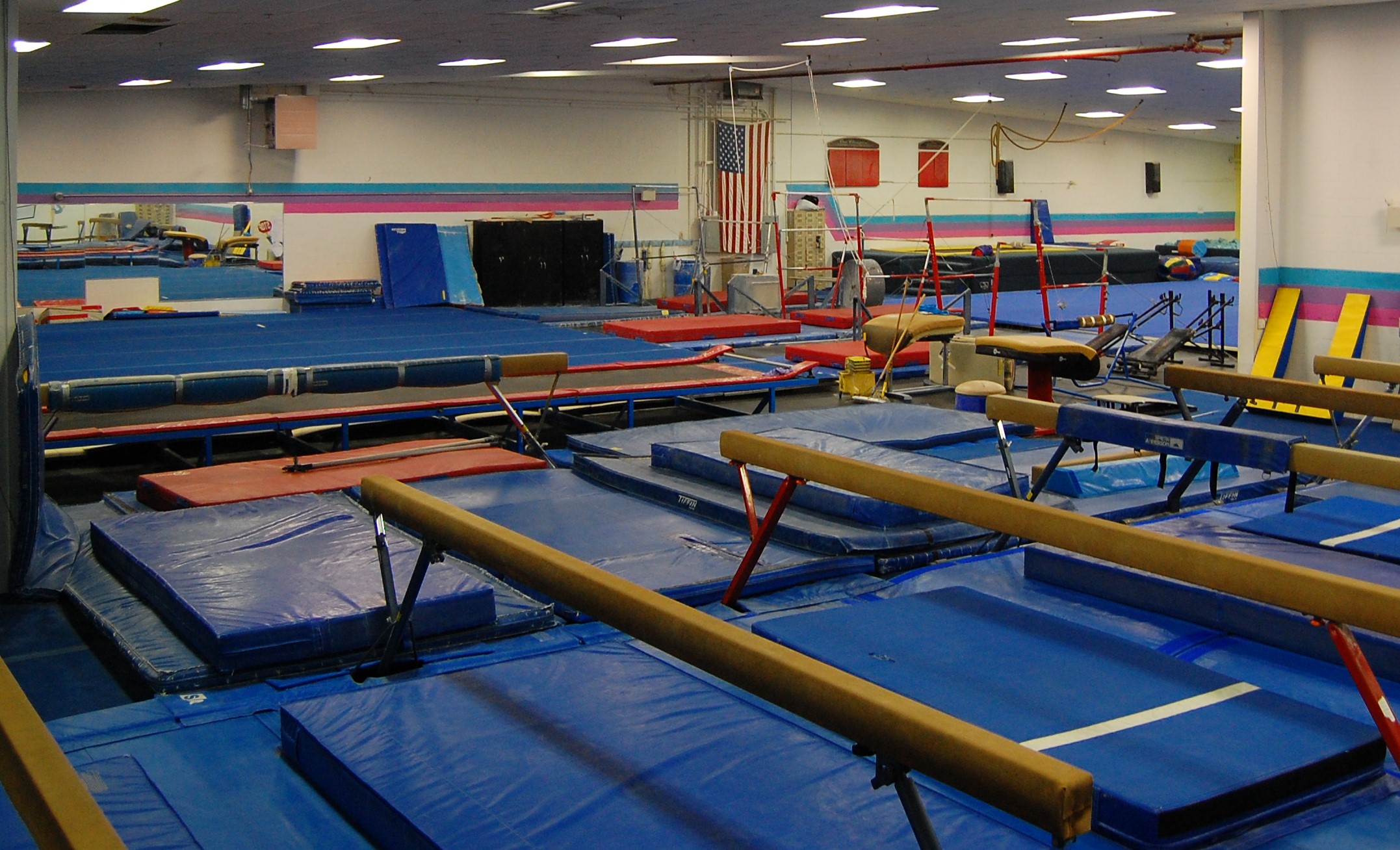 Indoor gymnastics facility with mats, balance beams, and equipment for training and practice.