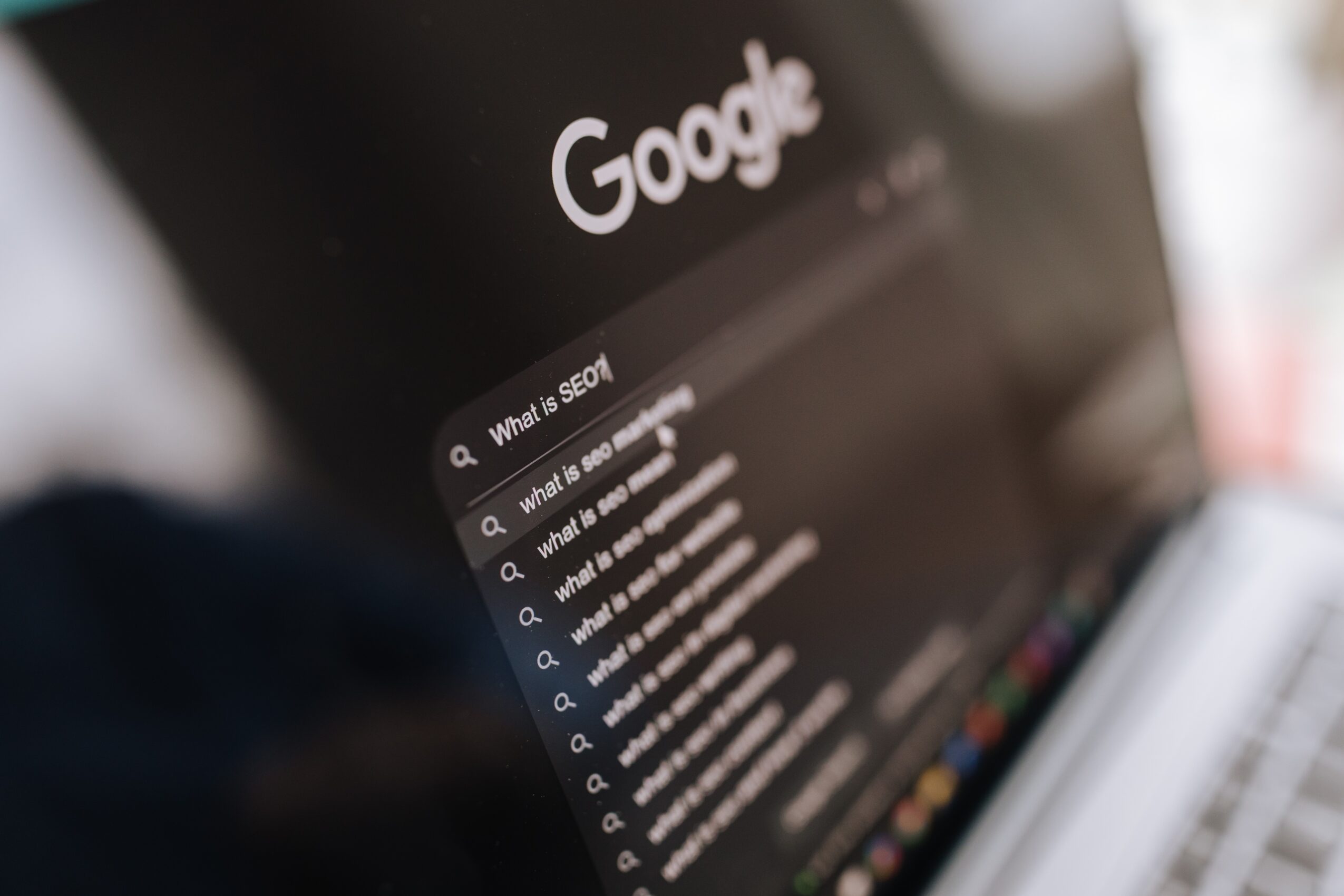 Screen displaying Google search page with search bar and search suggestions, slightly tilted view.