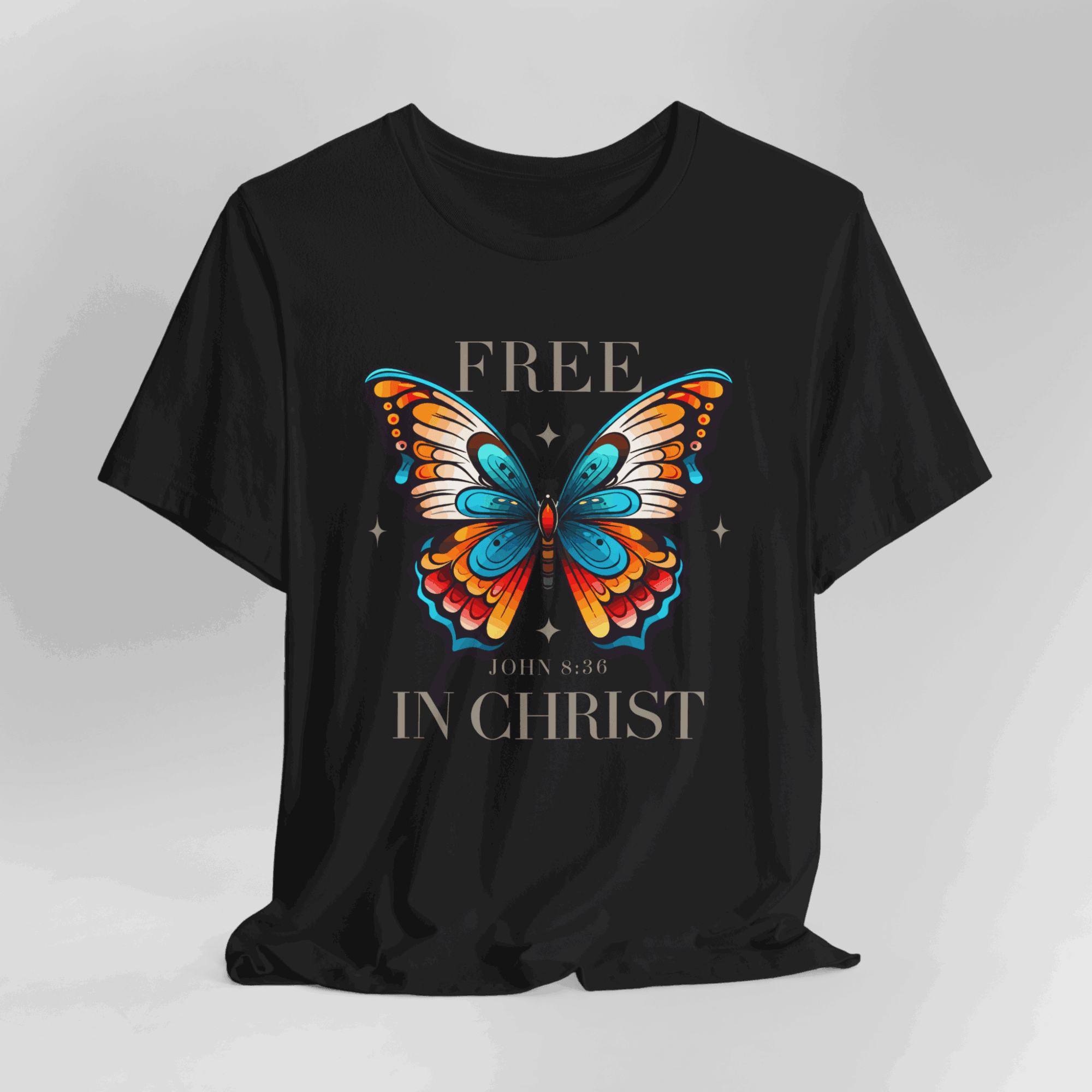 Black T-shirt with colorful butterfly and text 'FREE IN CHRIST' and a Bible verse reference.