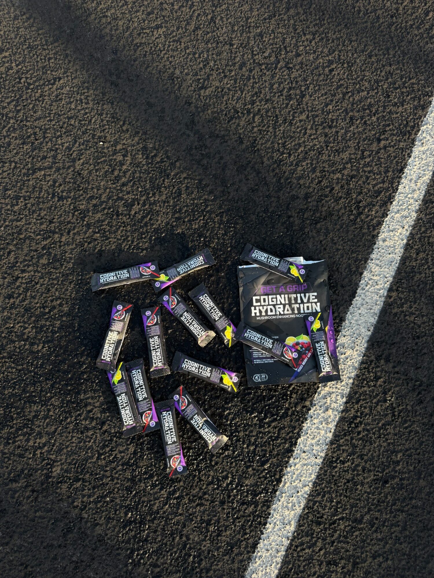 Multiple energy shot bottles and a box labeled 'Cognitive Hydration' on a textured surface with a white line.