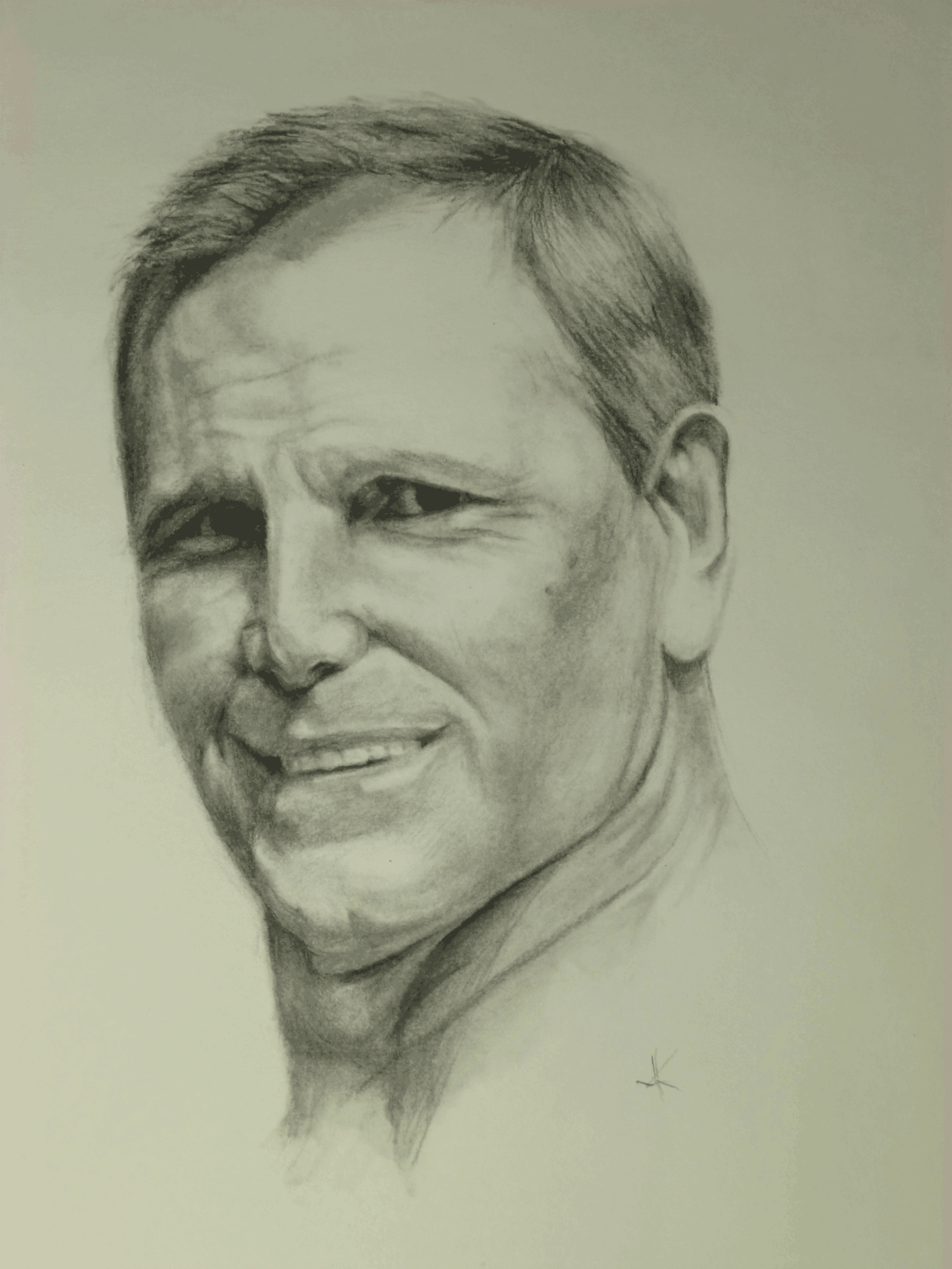 Sketch of a man's face with a slight smile, short hair, and visible neck, facing slightly to the left.