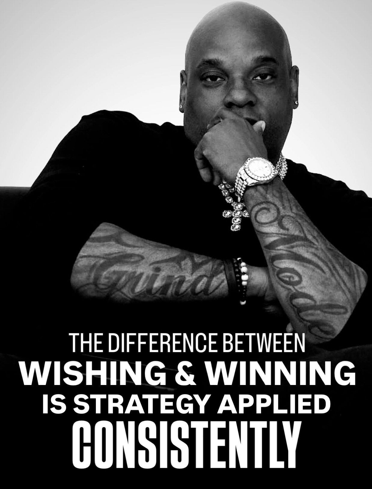 Man with tattoos and jewelry resting chin on hand, text about strategy and consistency, black and white image.