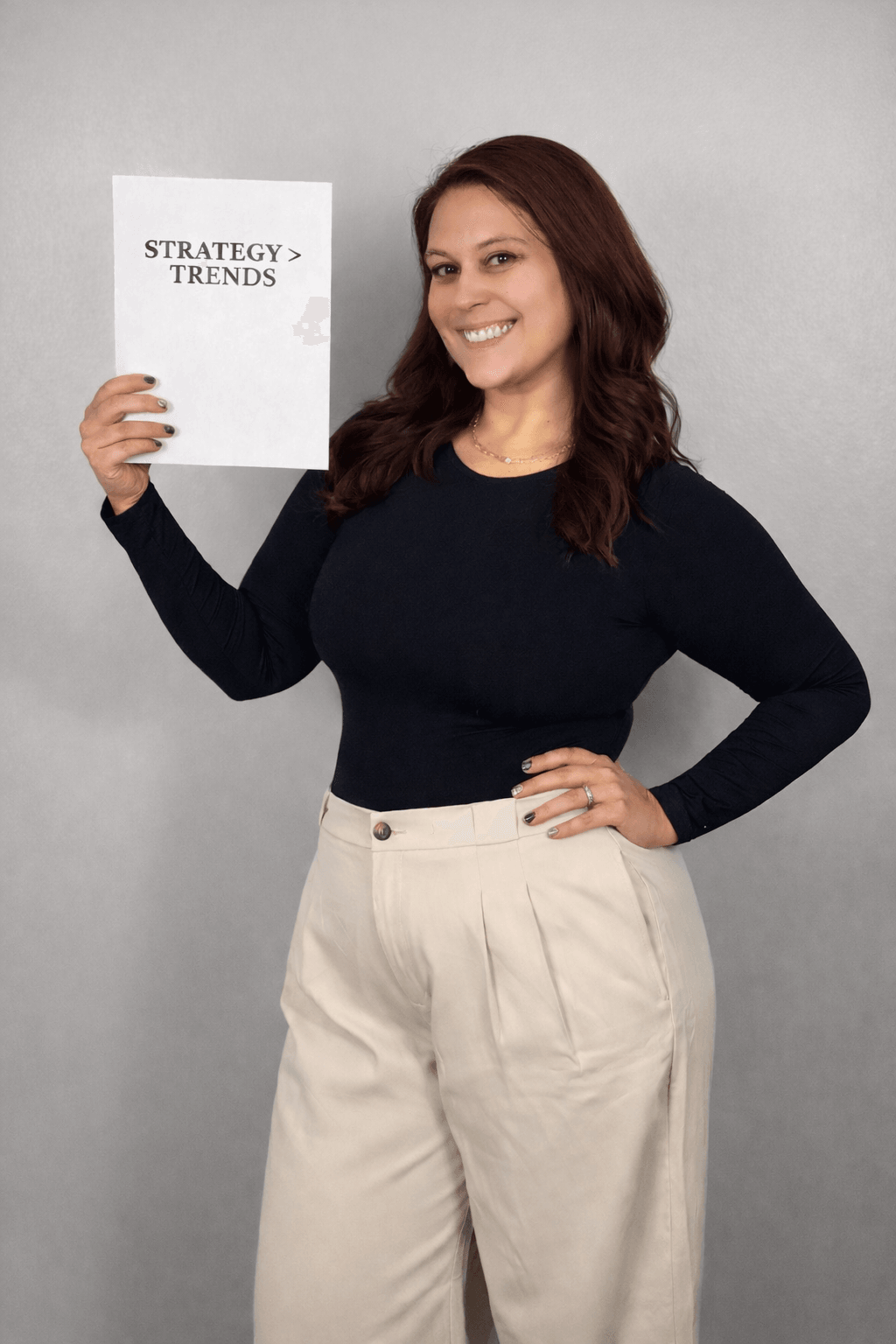 Woman smiling holding a paper titled 'Strategy srcset=