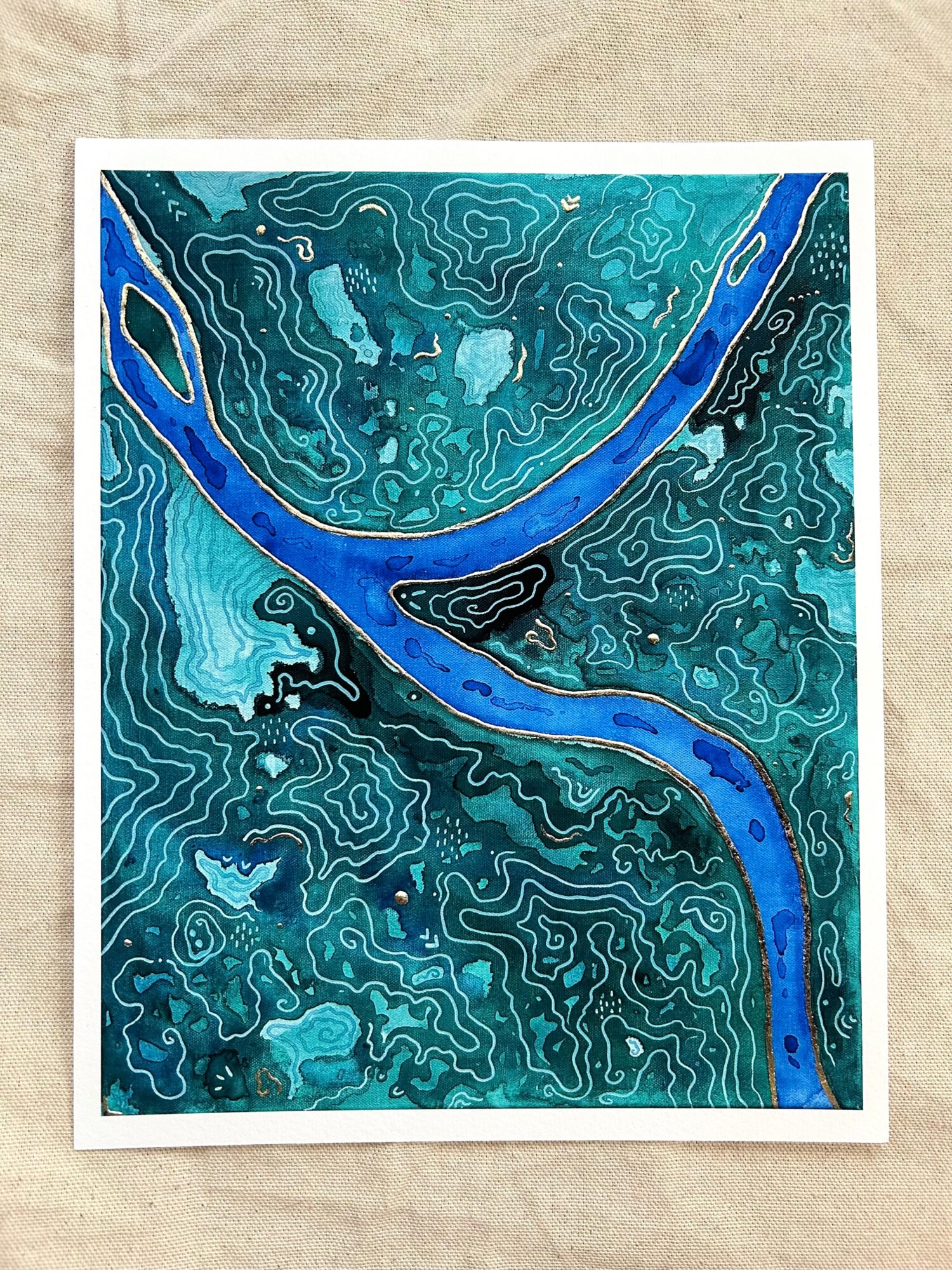 Abstract artwork with a blue river flowing through a teal and black patterned landscape, framed in white.