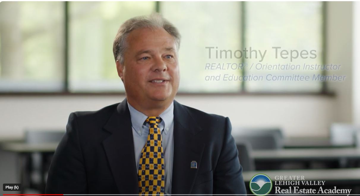 Man in suit and tie sitting in a room with large windows, smiling, with text overlay about Timothy Tepes and real estate.