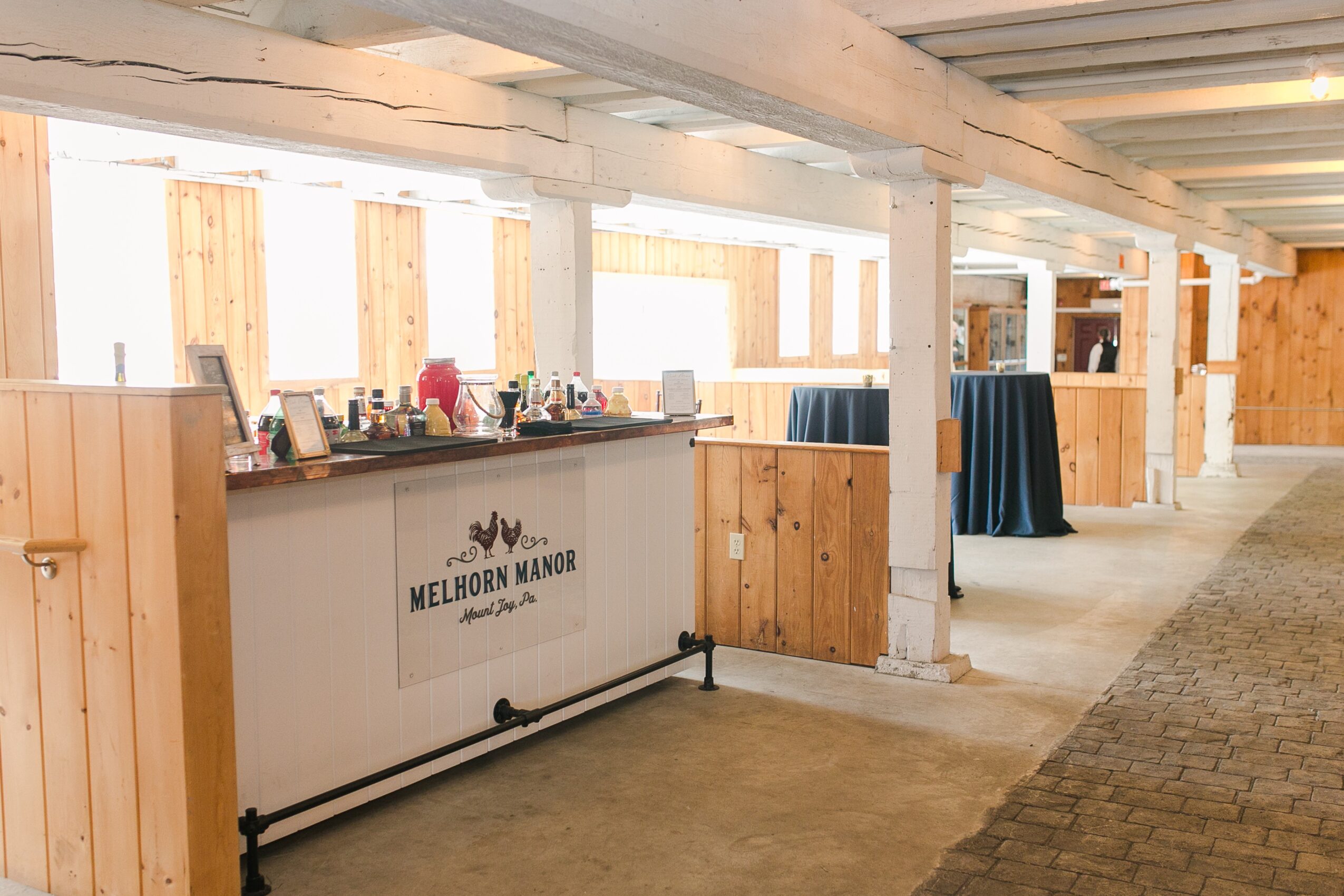 Reception area with wooden walls and a counter, sign reading Melhorn Manor, and a table with a blue tablecloth.