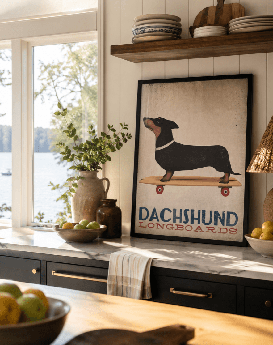 Kitchen counter with decorative items, a framed dachshund poster, and a window with trees outside.