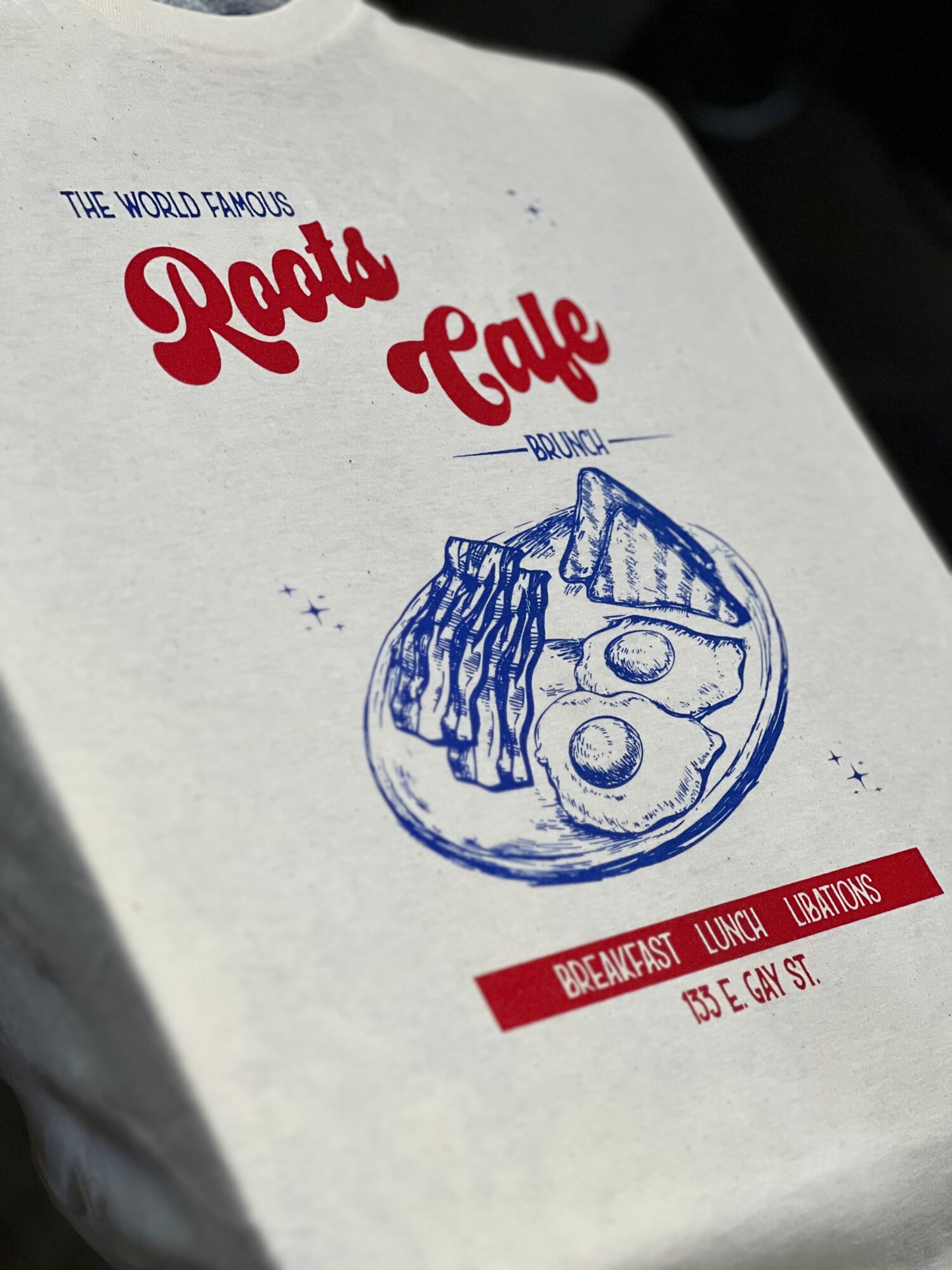 Paper bag with a blue sketch of a breakfast plate, red and blue text, and a red stripe at the bottom.