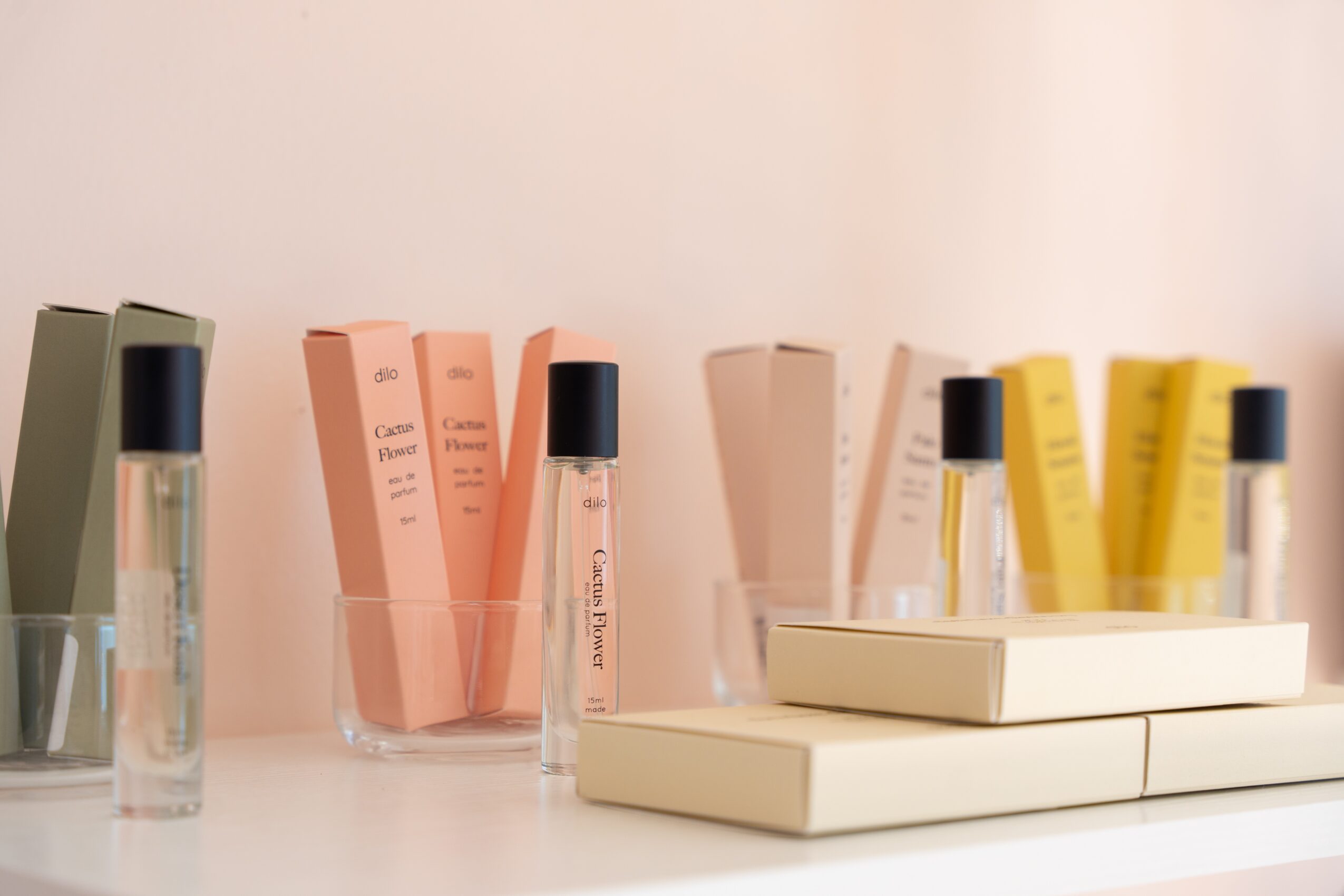 Collection of skincare or cosmetic products in bottles and tubes on a white surface, with a plain background.