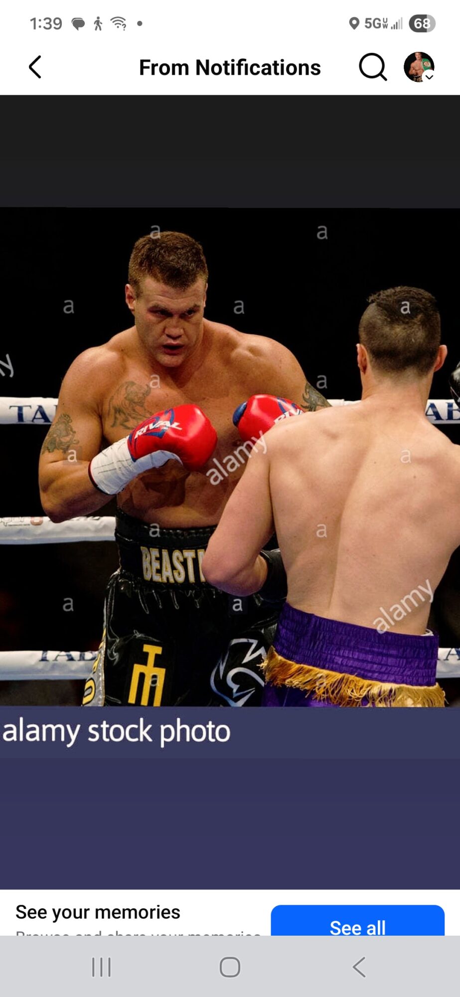 Two boxers in a match, one with red gloves and the other with purple shorts, engaged in a punch exchange.