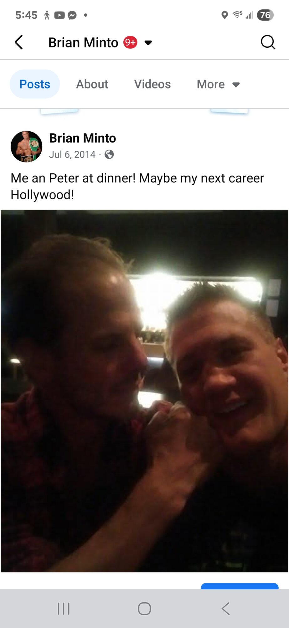 Two people smiling at dinner, with bright light behind them, in a dimly lit setting.