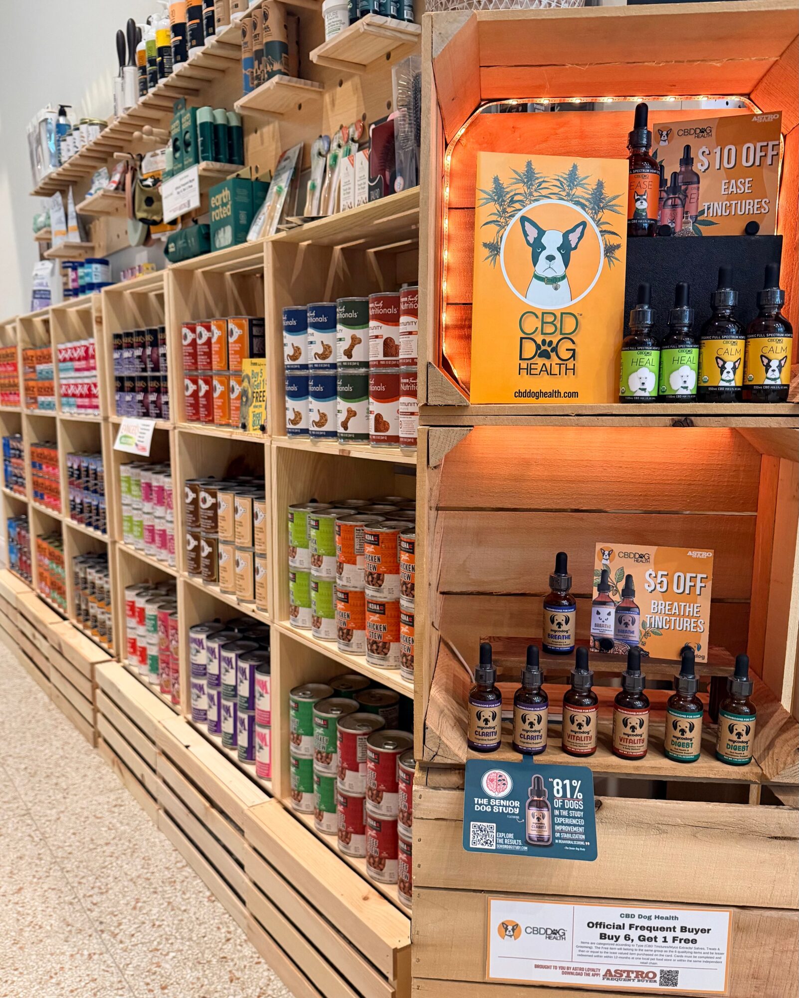 Shelves stocked with various bottles and products in a store, with a CBD product display on the right side.