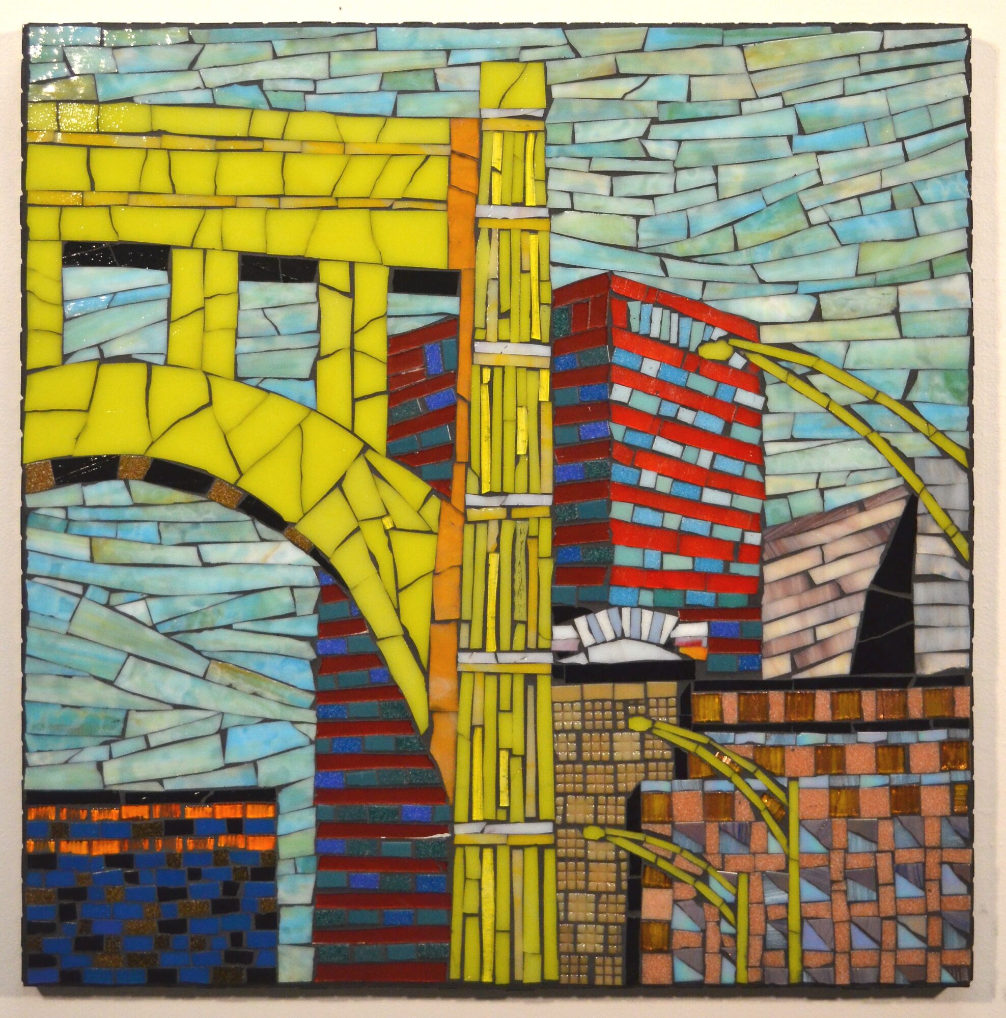 Colorful mosaic of buildings, bridges, and sky with yellow, red, blue, and brown tiles, viewed sideways.