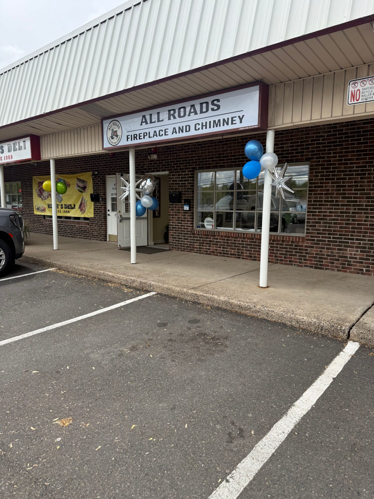 Exterior of a building with a sign reading 'All Roads Police and Crime' and blue and white balloons outside.