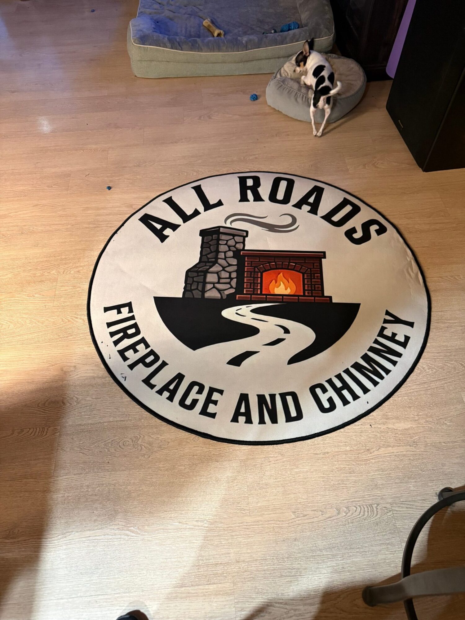Round sign with a black and white logo of a fireplace and a hand, reading 'ALLEY ROADS AND FIREPLACE AND CHIMNEY'.