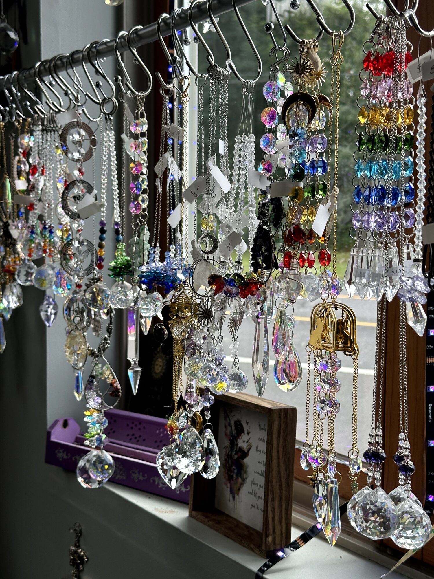 Display of hanging jewelry including necklaces, earrings, and bracelets with various beads and crystals, on a metal rack.