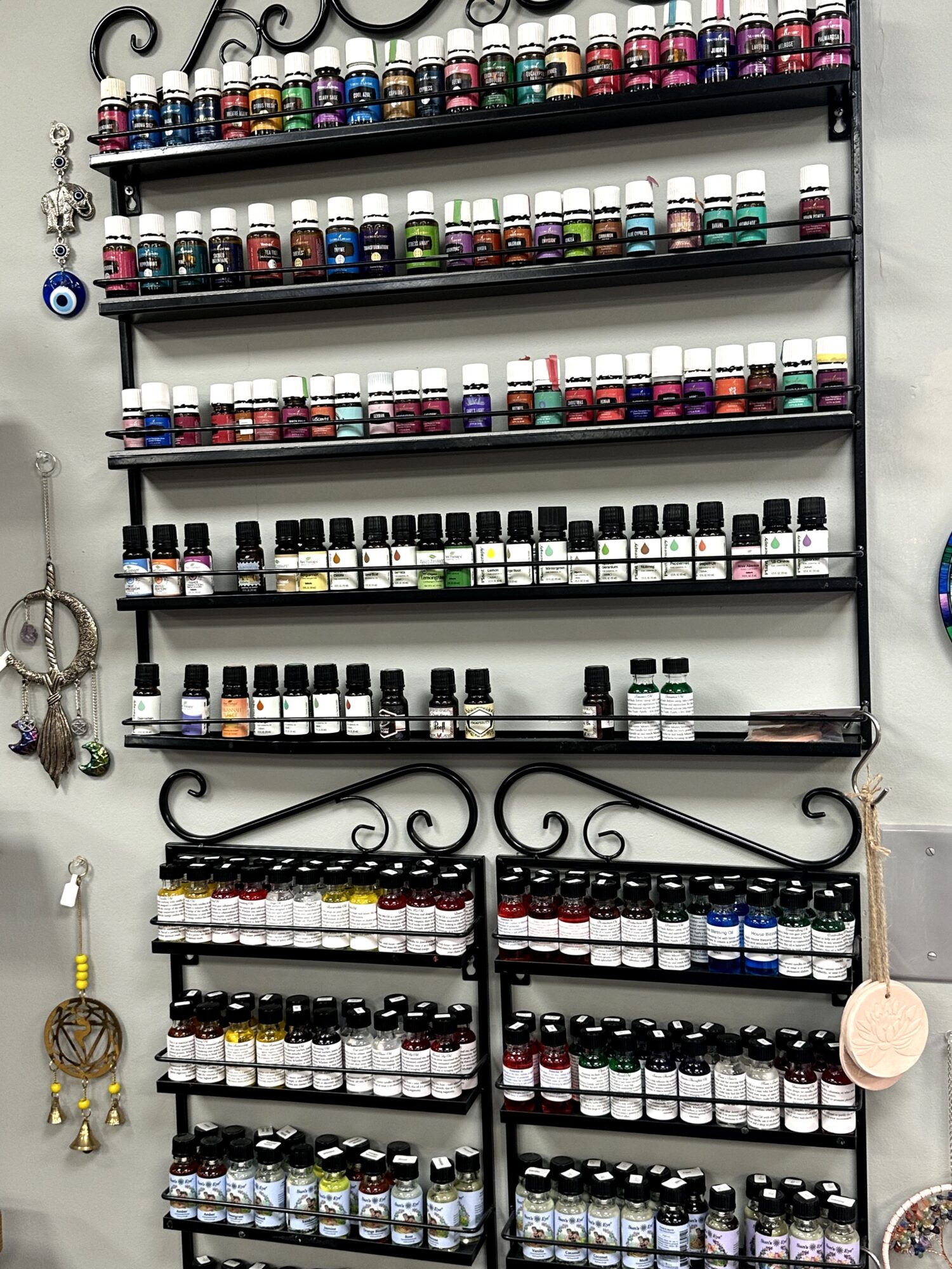 Display of multiple shelves filled with small bottles, possibly nail polish or essential oils, arranged in rows on a black metal rack.