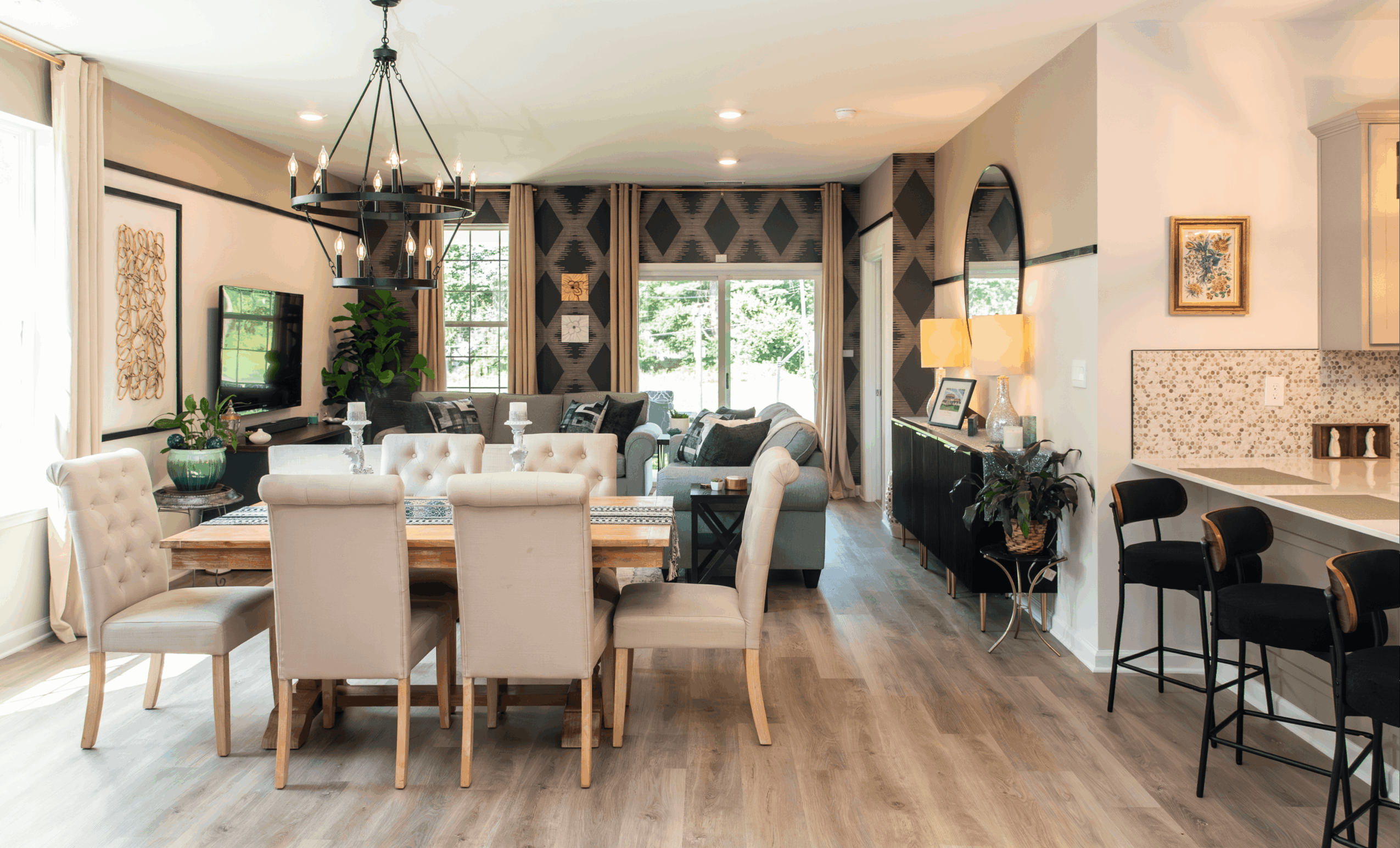 Open living and dining area with a large table, chairs, a TV, and a window with curtains, bright and spacious.