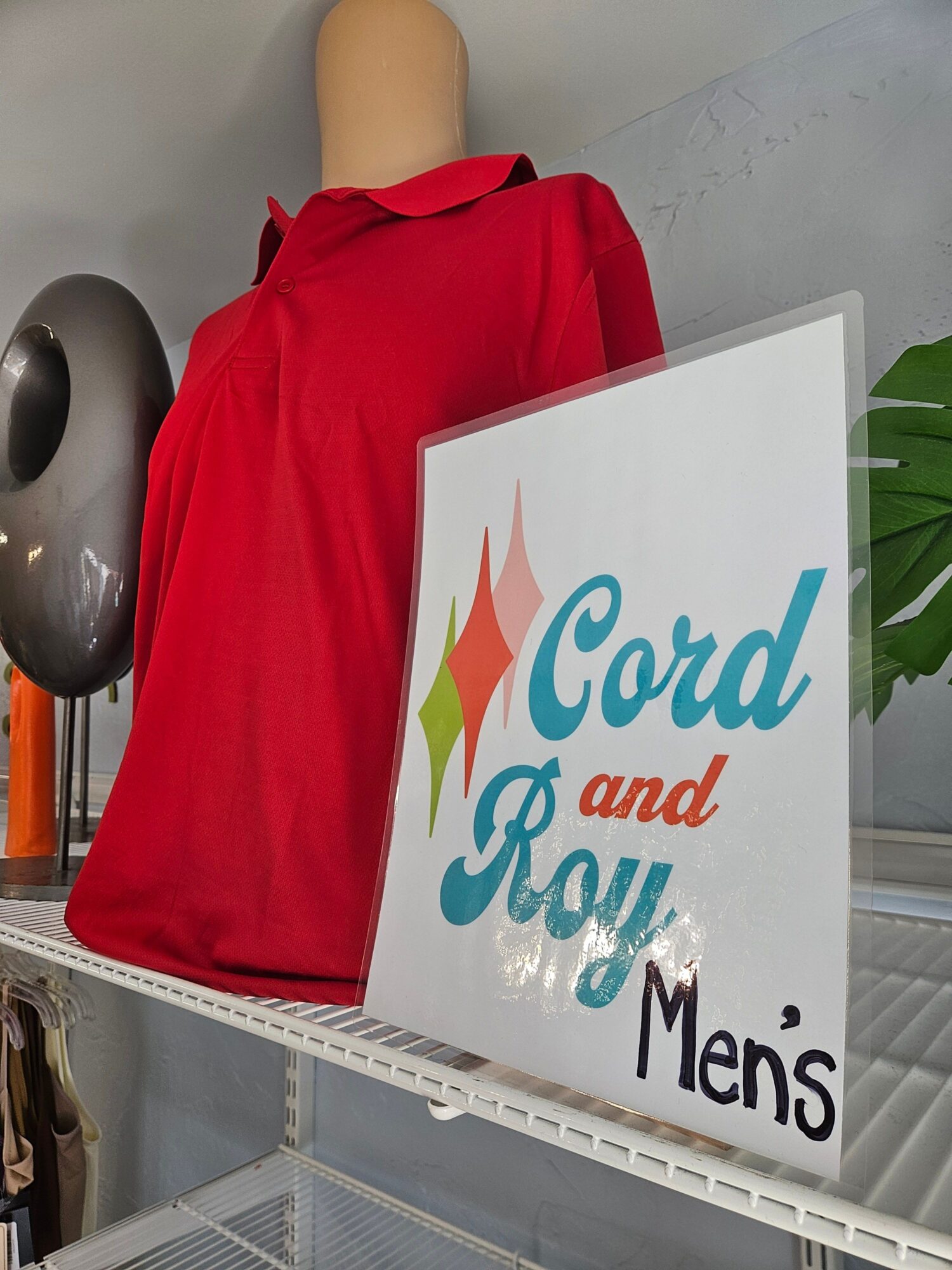 A person in a red dress stands behind a sign that reads 'Cared and Served Men'.