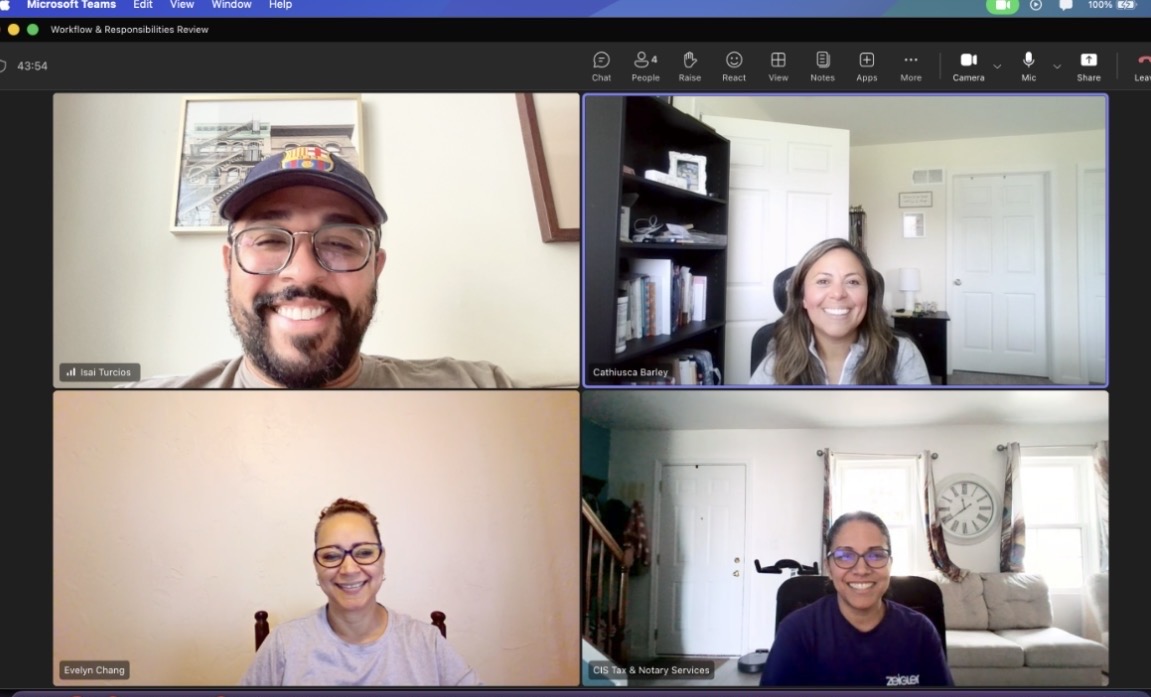 Four people smiling in a video call, each in different indoor settings.