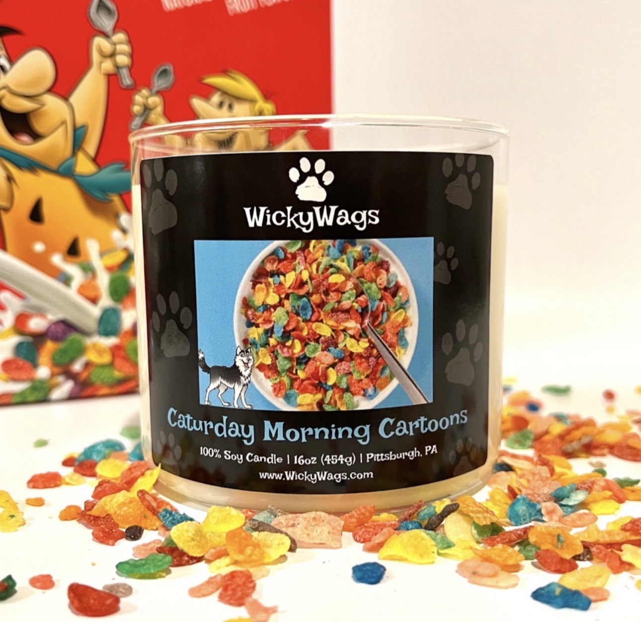 Clear glass jar with a black label featuring colorful candy and cartoon characters, surrounded by scattered candies, with a red and white background.