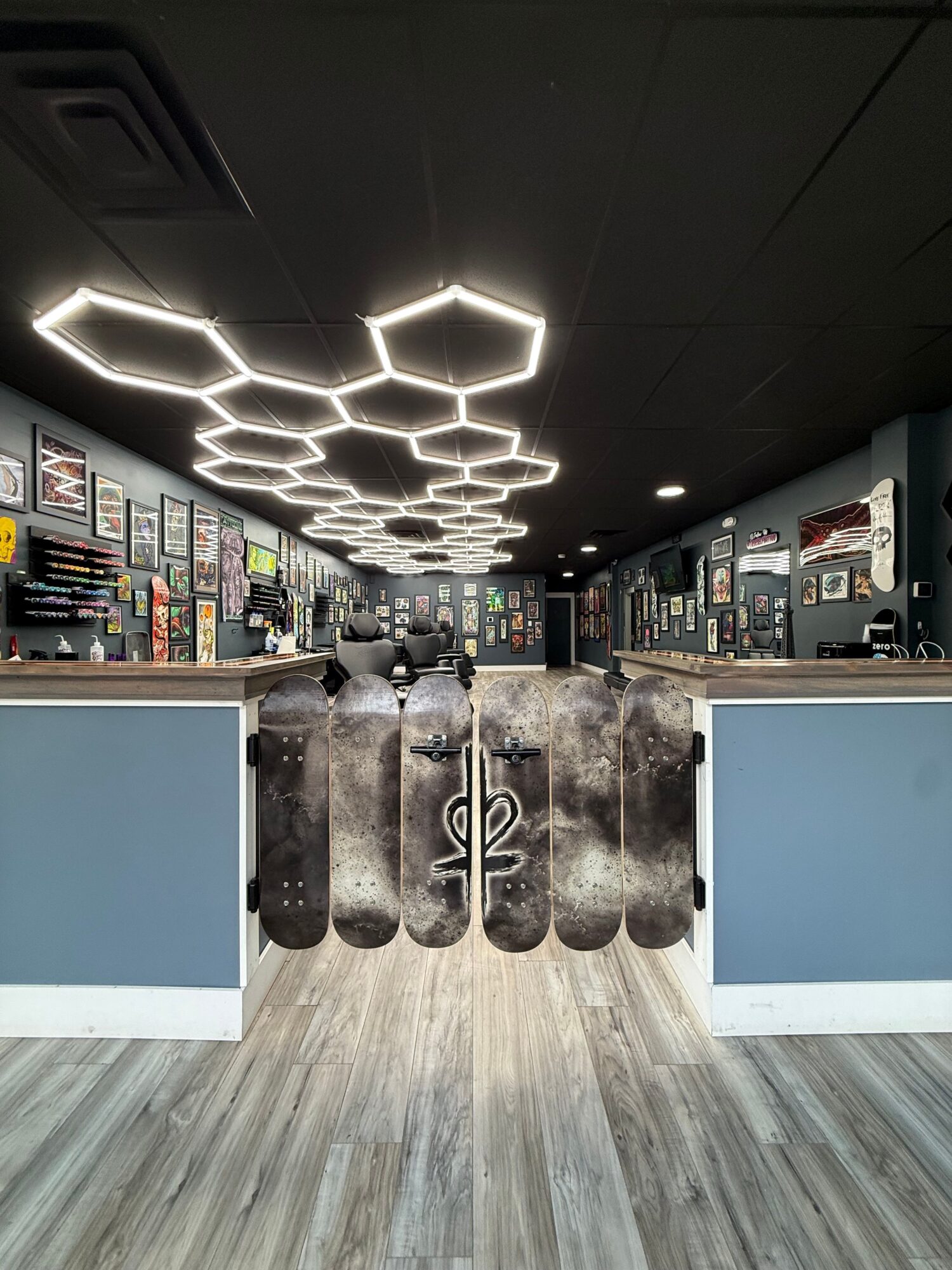 Modern bookstore with hexagonal light fixtures on ceiling, bookshelves, and a wooden floor, viewed from the side. Word 'book' visible on wall.