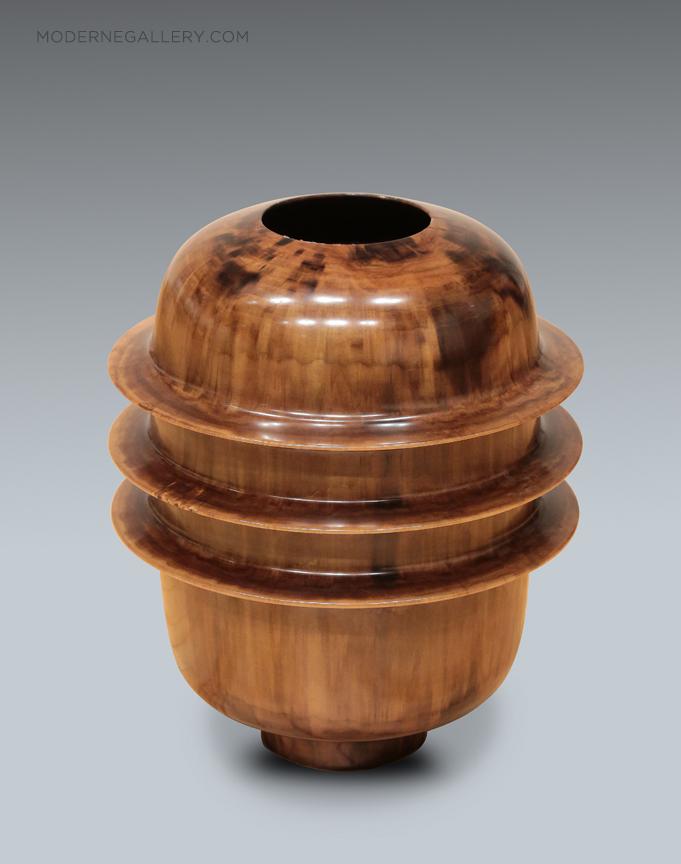 Wooden vase with a rounded top and three horizontal ridges, set against a plain background.