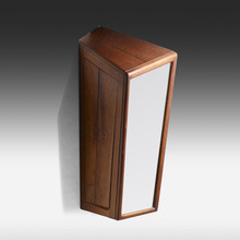 Tall wooden speaker with a white front panel, standing on a dark gradient background.