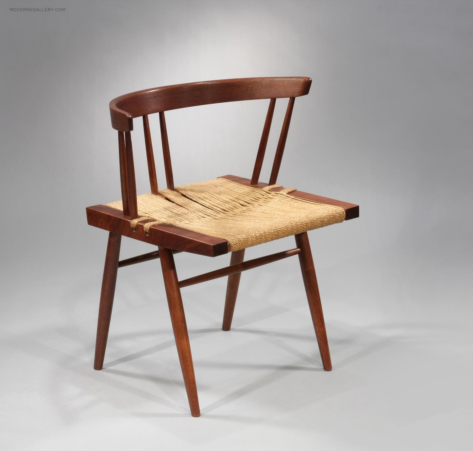 Wooden chair with a curved backrest and woven seat, set against a plain background.