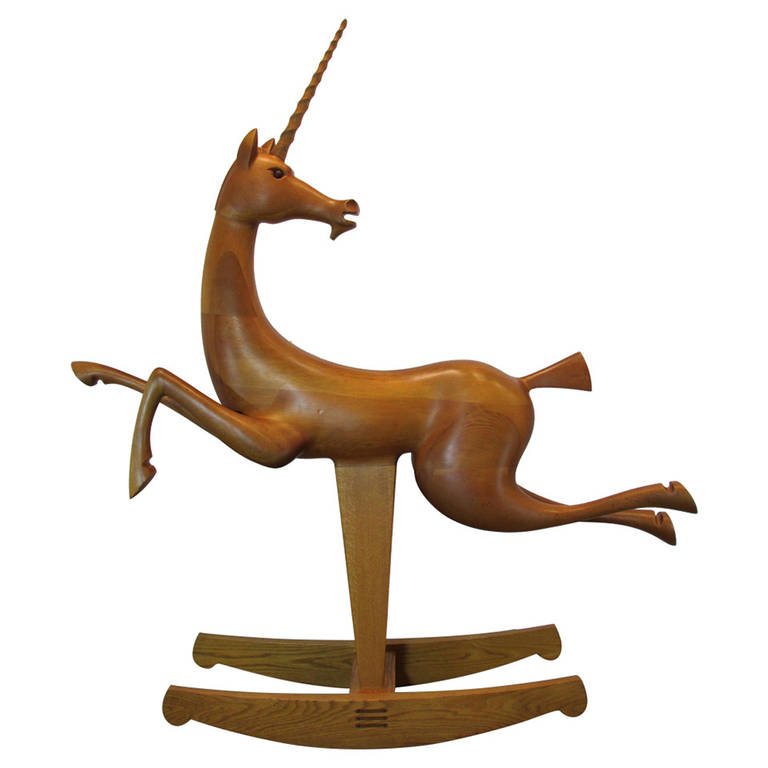 Wooden unicorn rocking horse with a horn, standing on curved base, facing right, with a white background.