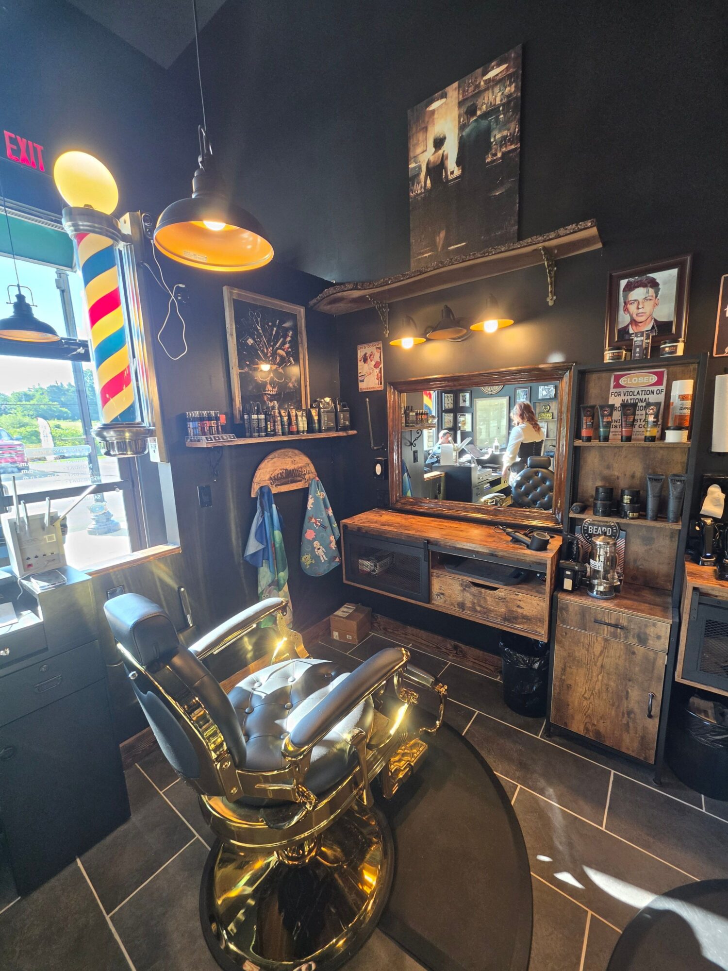 Bar area with a golden trophy, colorful barber pole, and a person standing near the counter inside a dimly lit space.