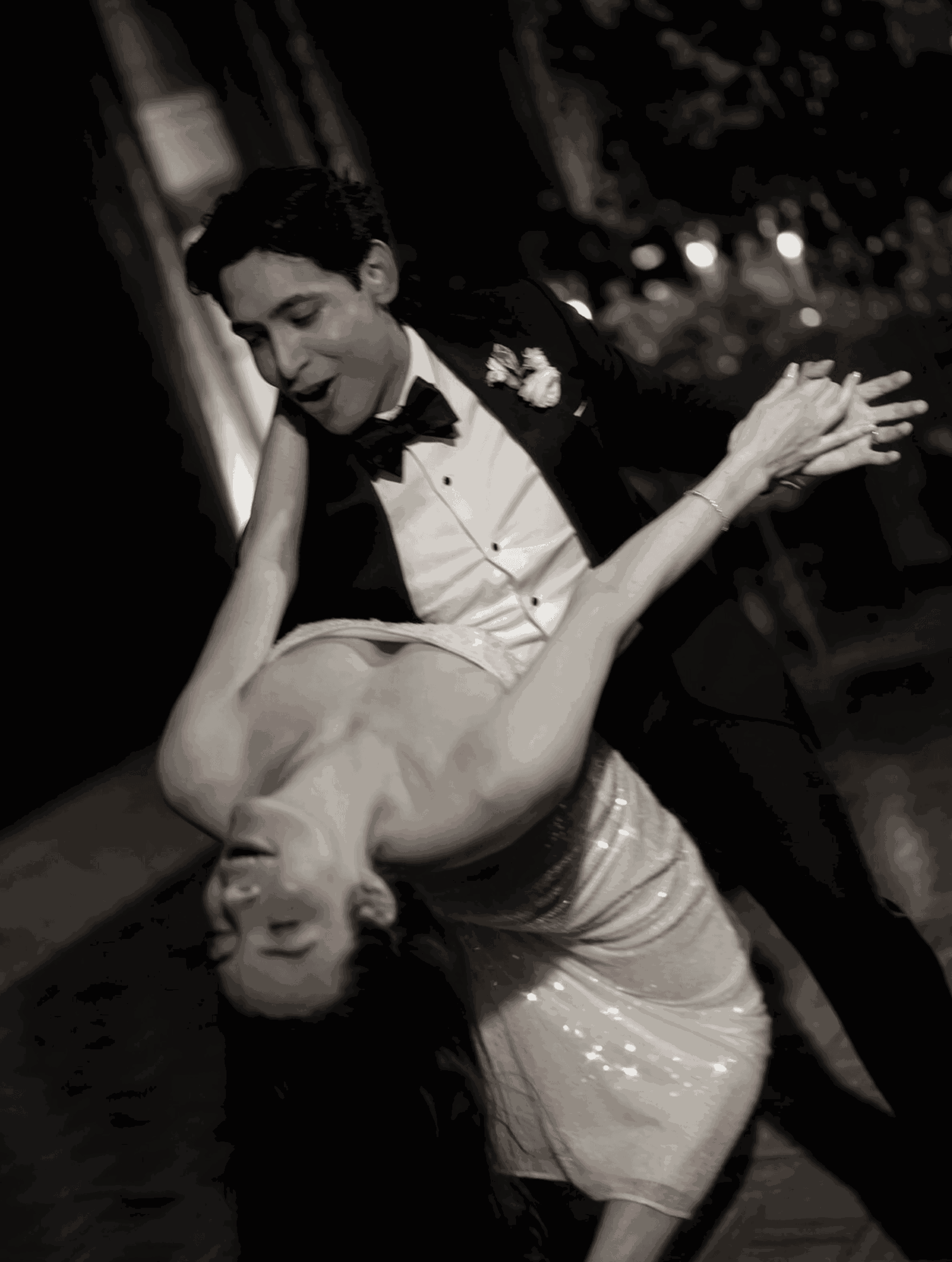 A man and woman dance closely, the woman leaning back with her eyes closed, the man smiling, in black and white.