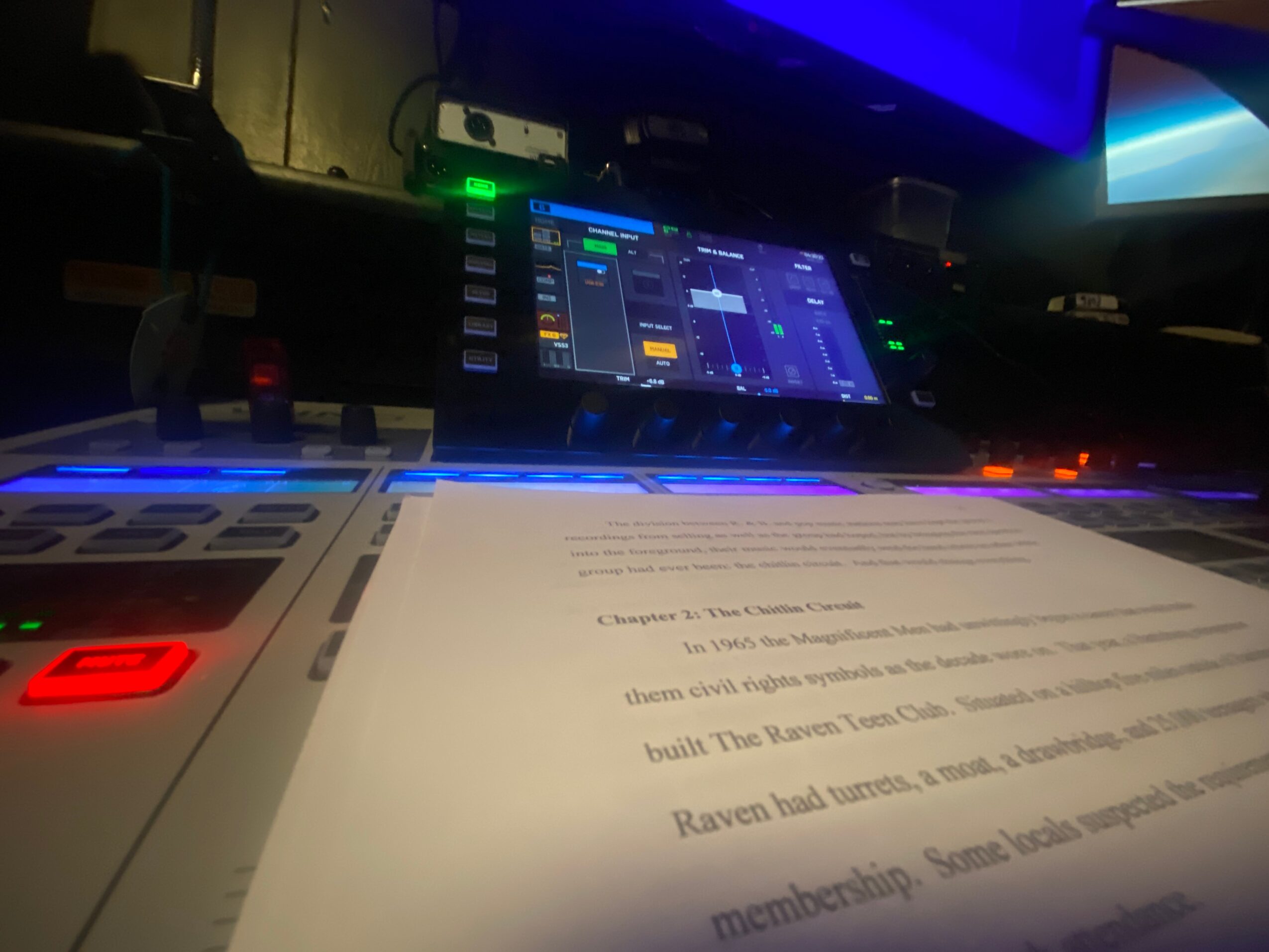 DJ equipment with a tablet displaying a music mixing app, a sheet of paper, and a computer monitor in the background.