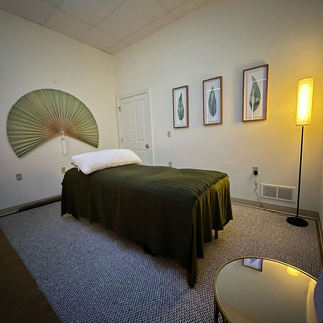 Bedroom with a bed, wall art, a floor lamp, and a decorative fan on the wall.