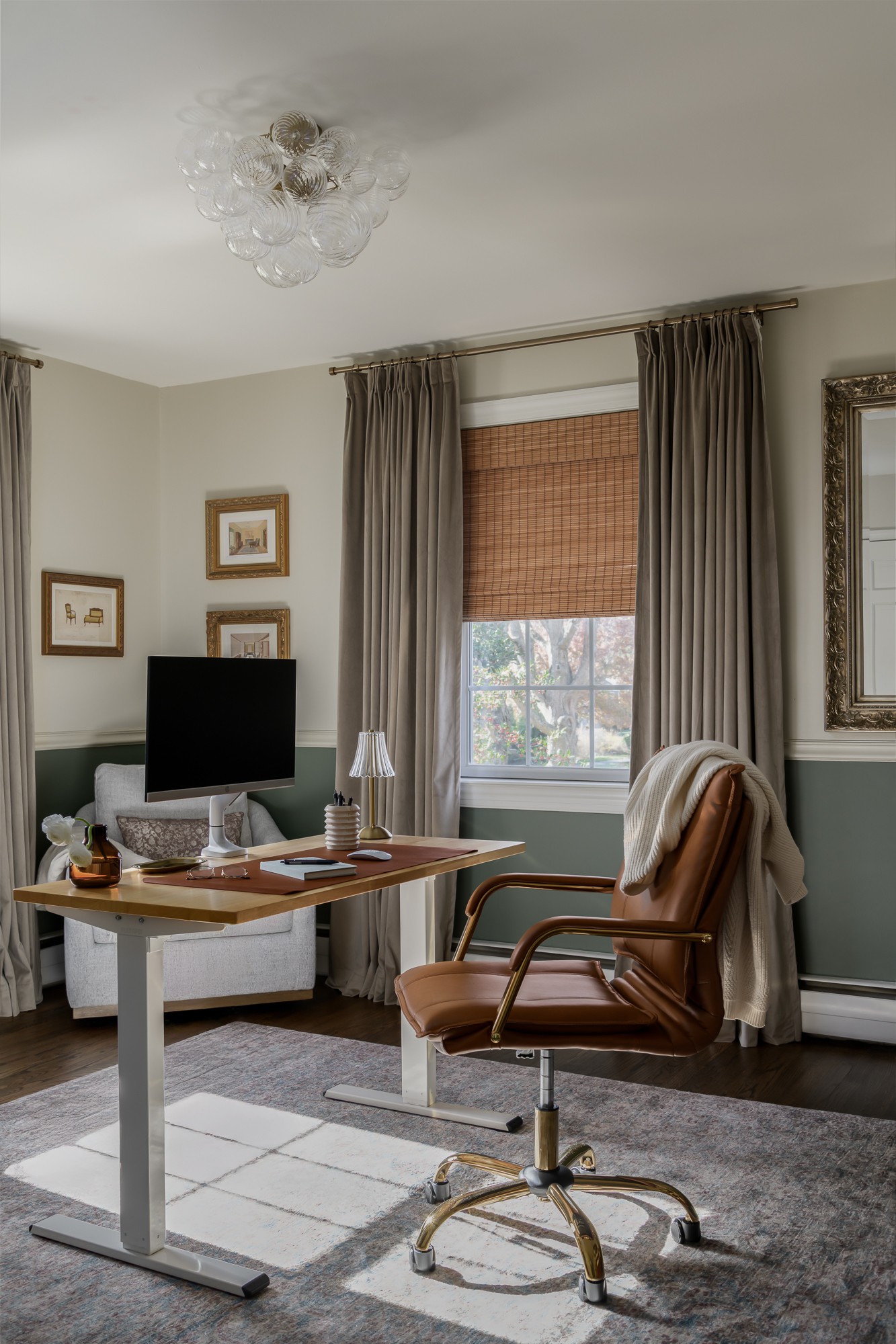 Home office with desk, chair, window with curtains, and wall decorations, sunlight on the floor.