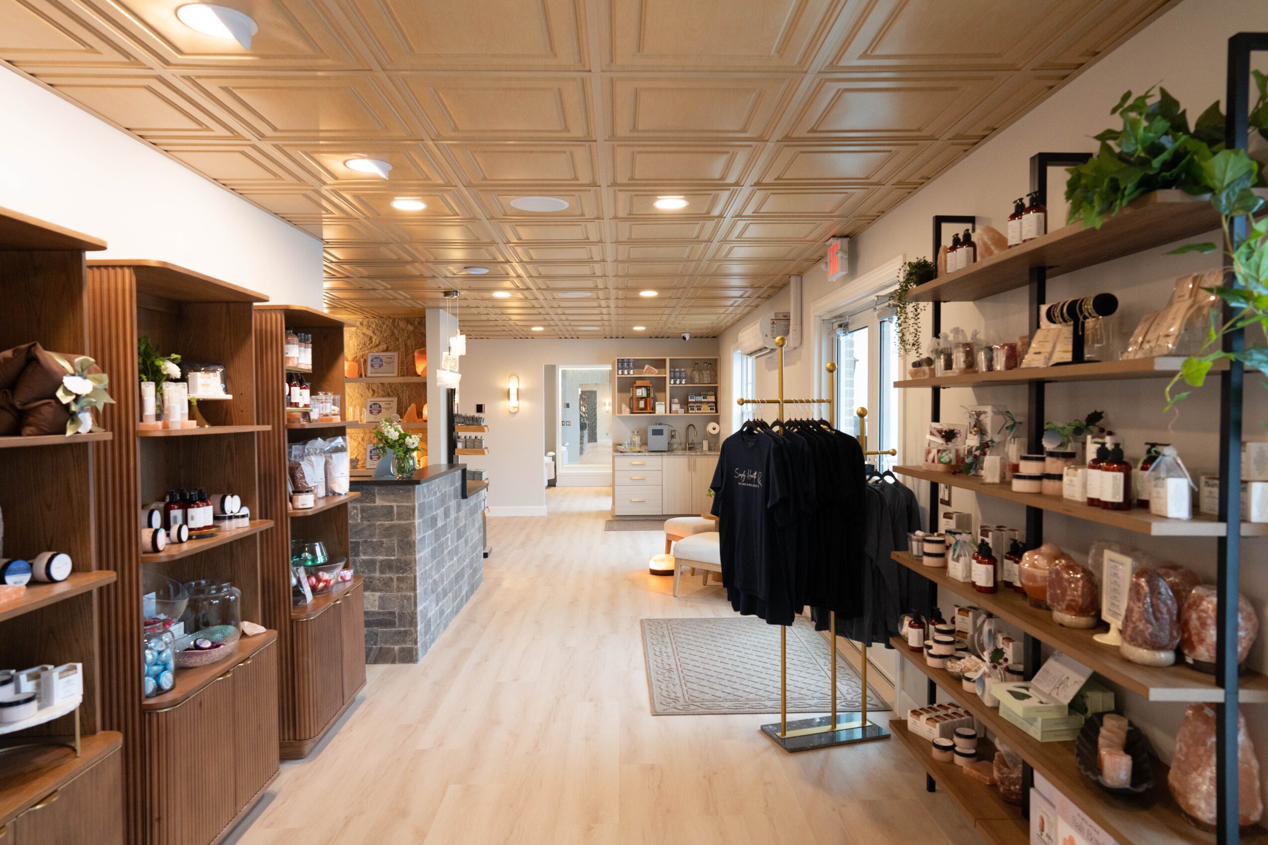 Interior of a store with wooden shelves displaying various items, light-colored flooring, and ceiling lights.