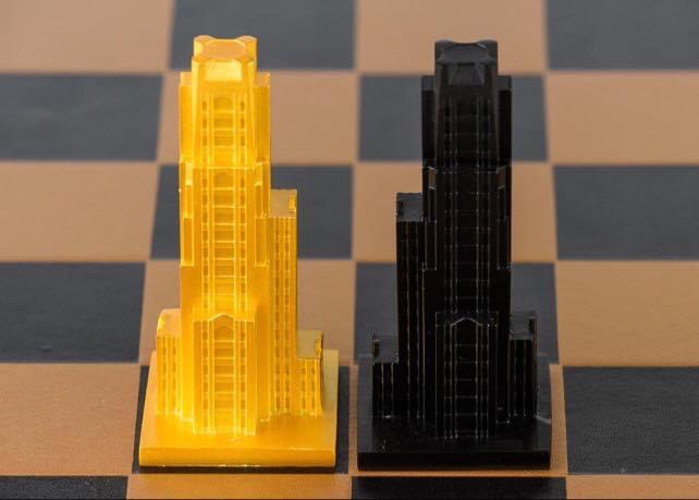 Two chess rooks, one yellow and one black, placed on a chessboard. The yellow rook is on the left, the black on the right.