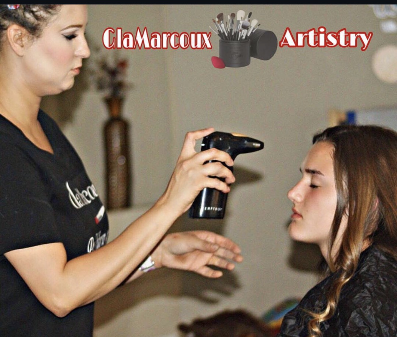Makeup artist sprays setting spray on a woman's face in a salon. Text reads 'ClaMarcoux Artistry'.