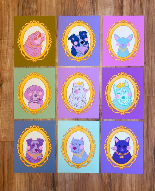 Nine colorful cards with illustrated animals in ornate frames, arranged in a 3x3 grid on a wooden surface.