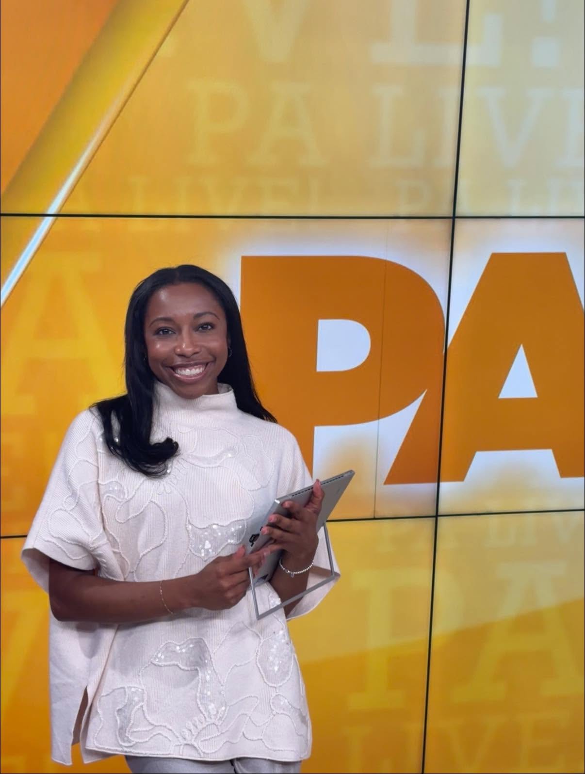 Smiling woman holding a tablet in front of a large yellow and white background with text.