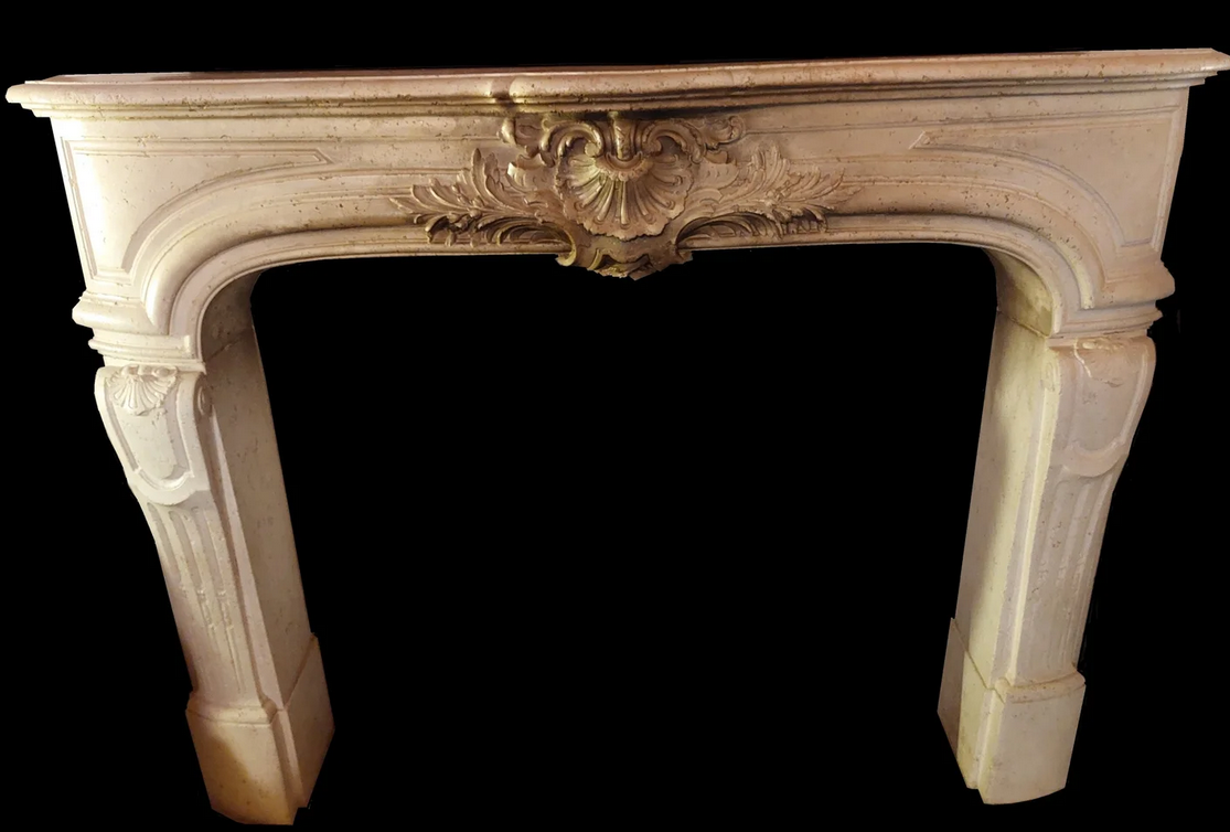Ornate cream-colored fireplace mantel with decorative carvings and curved design, set against a black background.