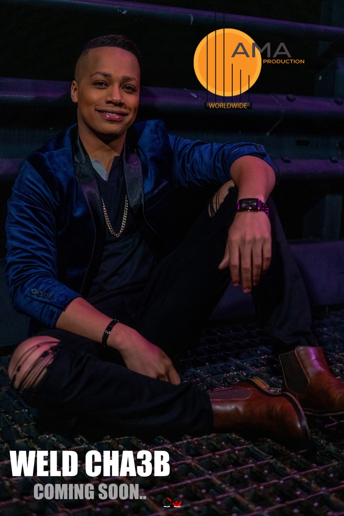 Young man sitting on a dark surface, smiling, wearing a dark jacket, with a logo in the top right corner, and text at the bottom.