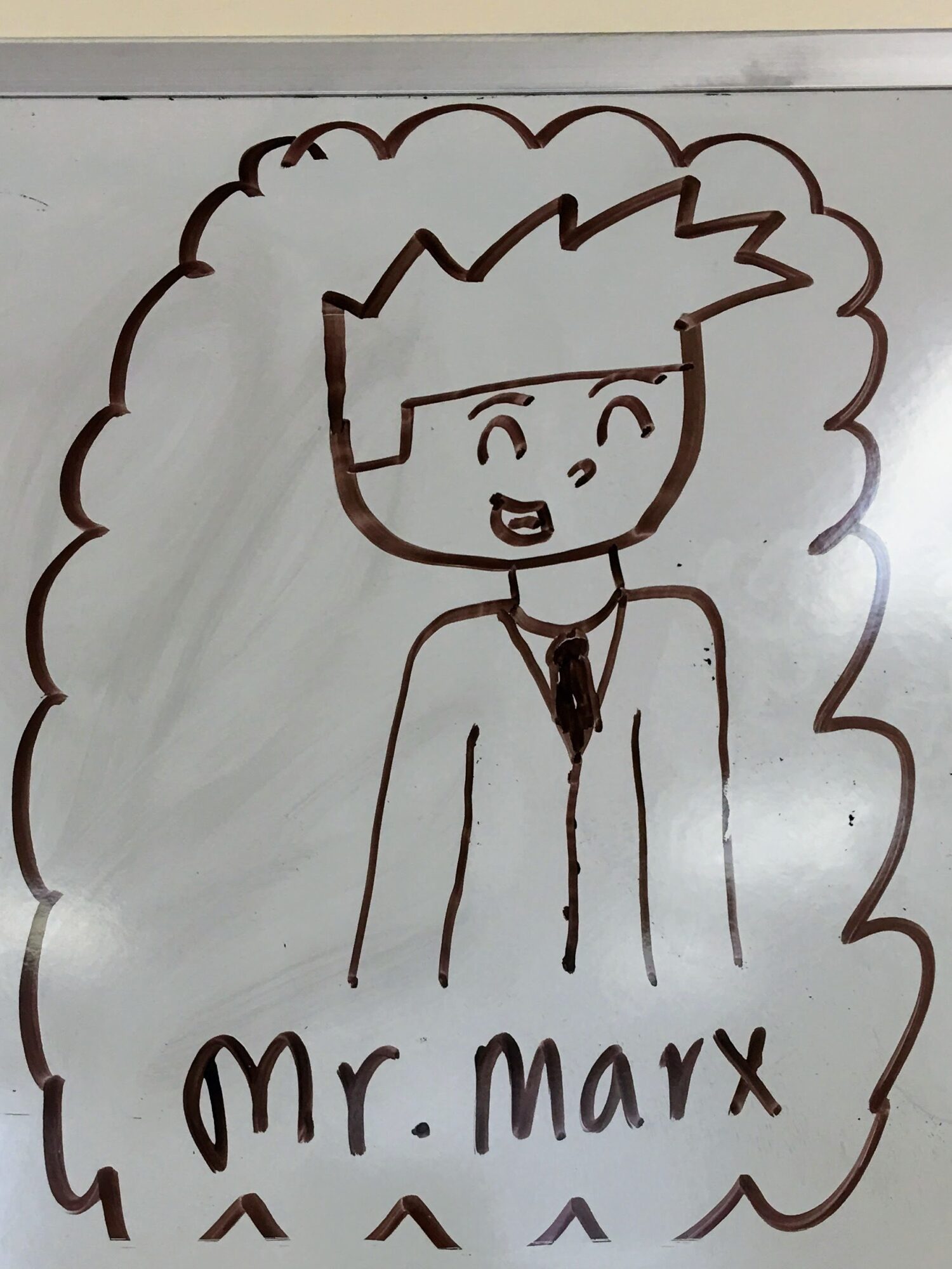 Cartoon character with spiky hair, smiling, wearing a suit and tie, labeled 'Mr. Marx' below, surrounded by a cloud-like border.