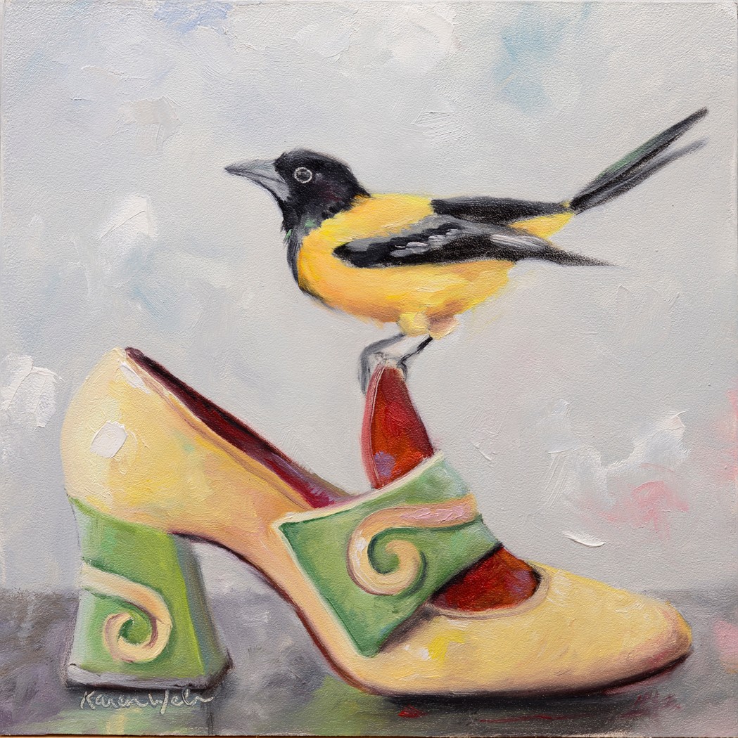 A bird with yellow and black feathers perched on a colorful high-heeled shoe against a light background.