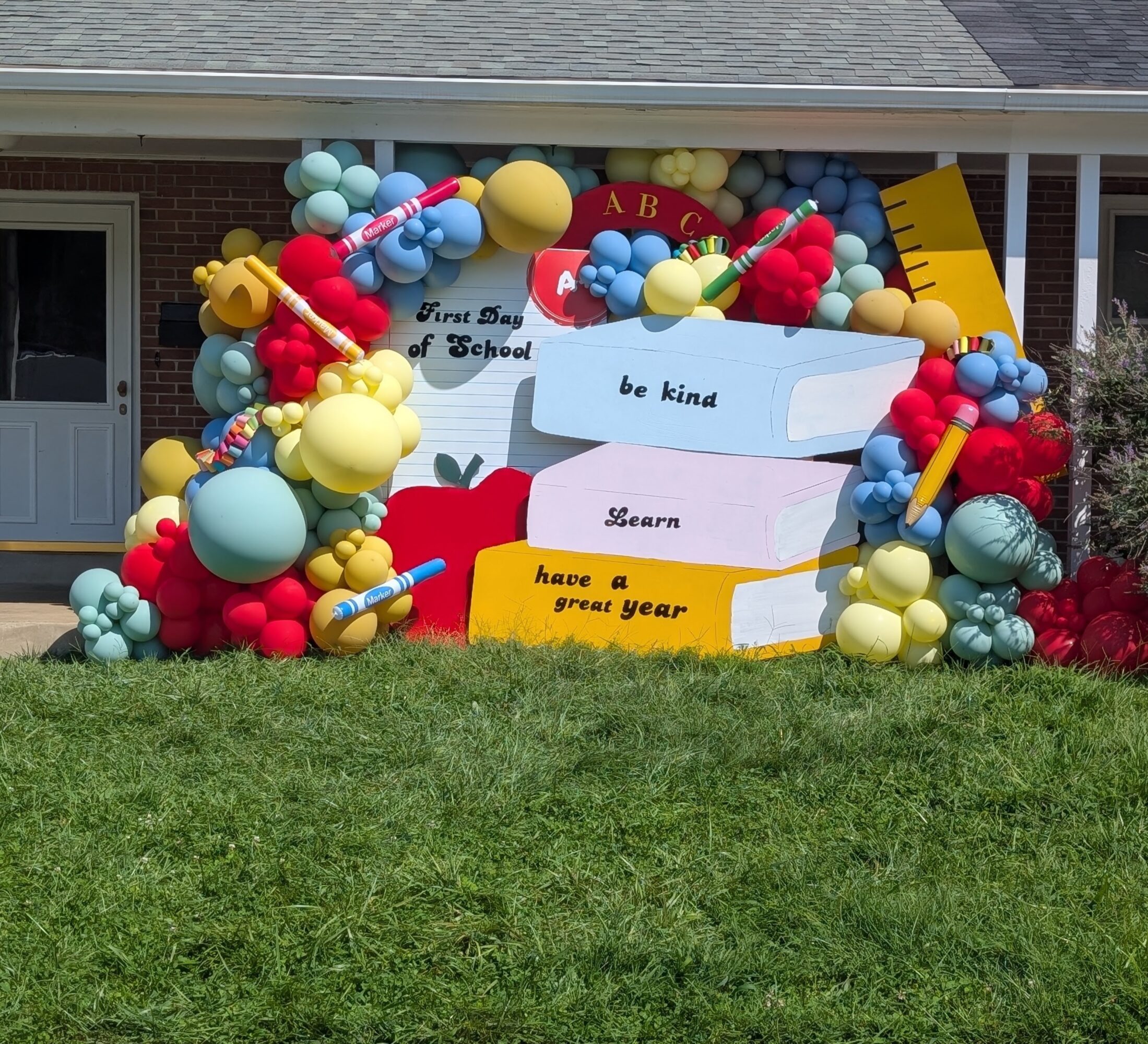 Decorative school-themed display with balloons, books, and a sign reading