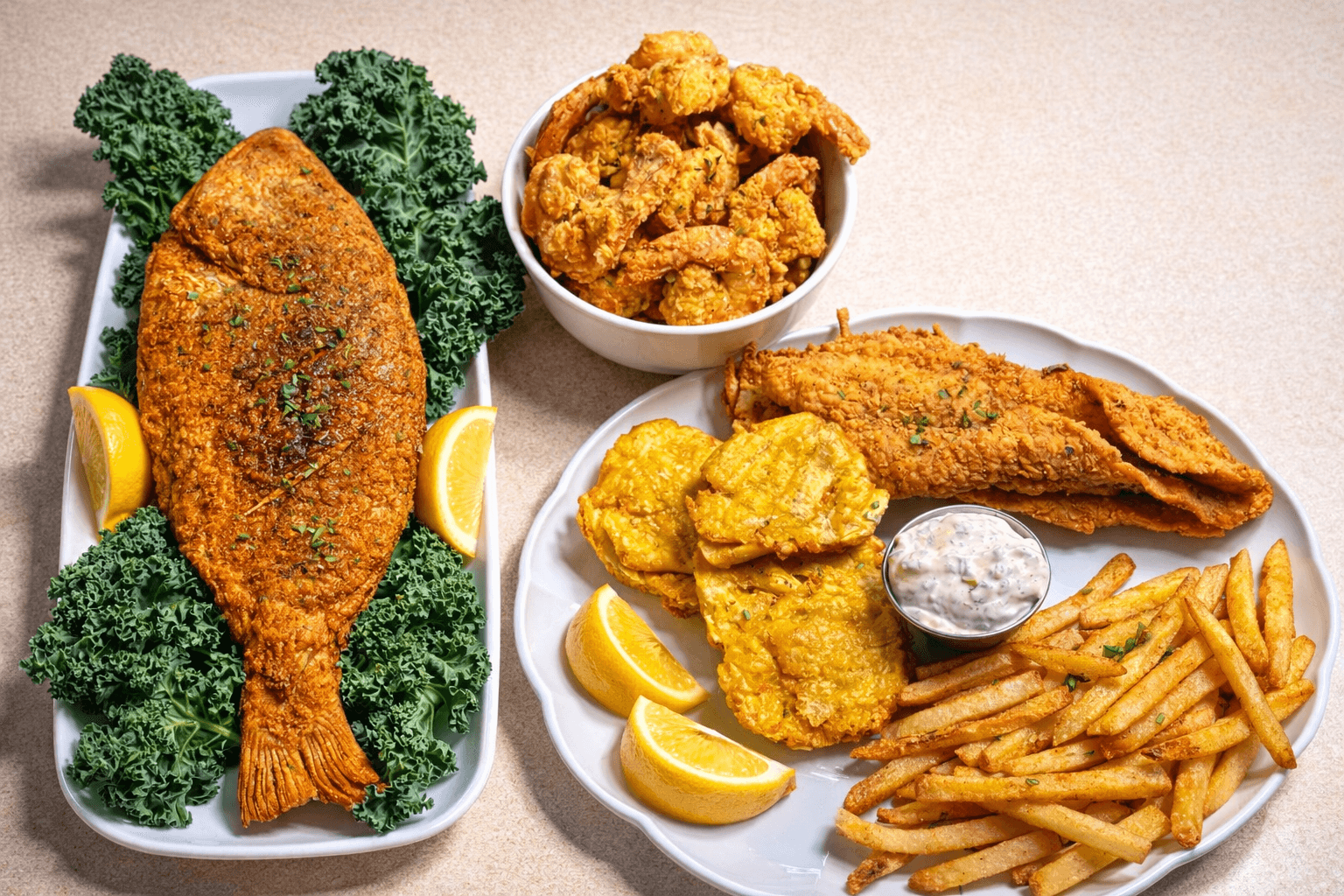 Plate with fried fish, lemon wedges, and greens; bowl of fried chicken pieces; plate with fried fish, fries, and dipping sauce.